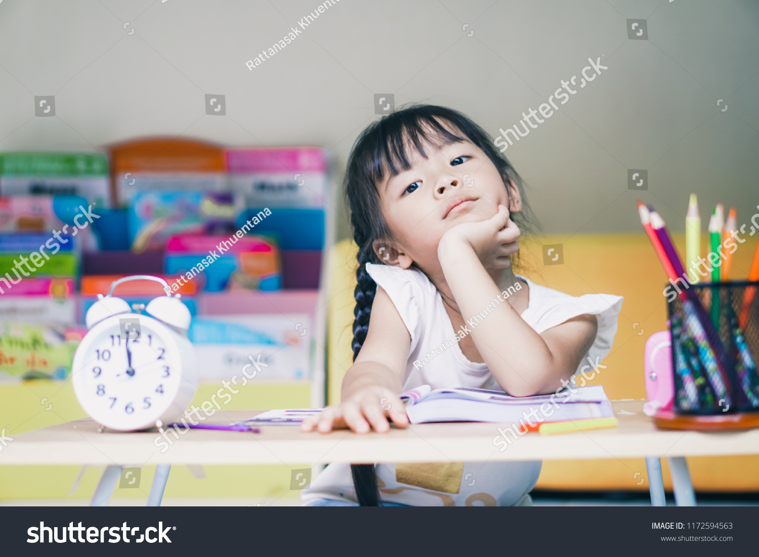 little student asian girl boring study lie down on a table. suffering from headache while doing overwork with learning , homework , study . school children education habit and parent concern concept. #1172594563