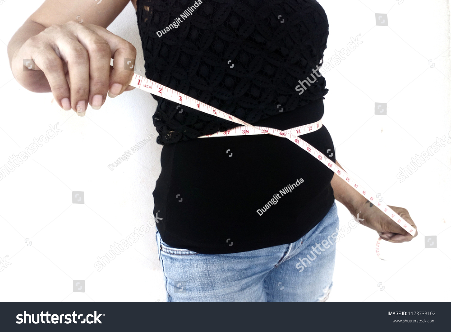 Women wearing black shirts, wearing black jeans Use the measuring device .. Waist measurement. #1173733102