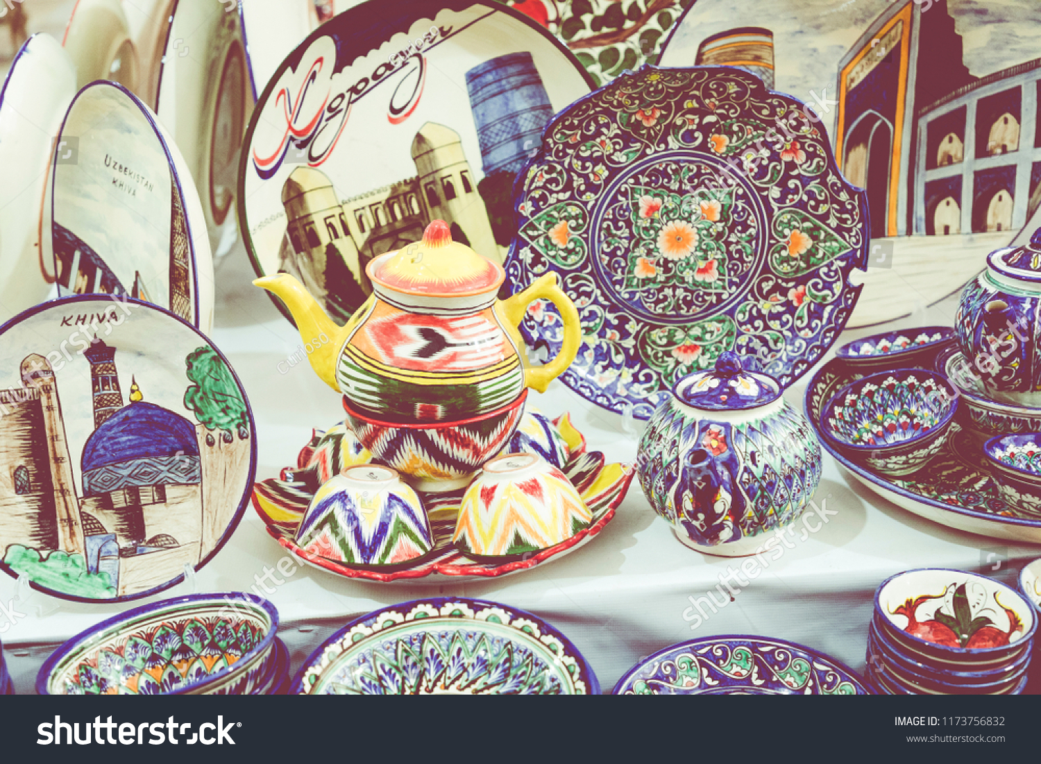 KHIVA, UZBEKISTAN - AUGUST 26, 2018: Plates and pots on a street market in the city of Khiva Uzbekistan. #1173756832
