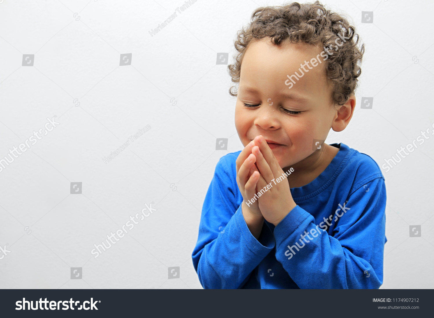 small boy praying stock photo #1174907212