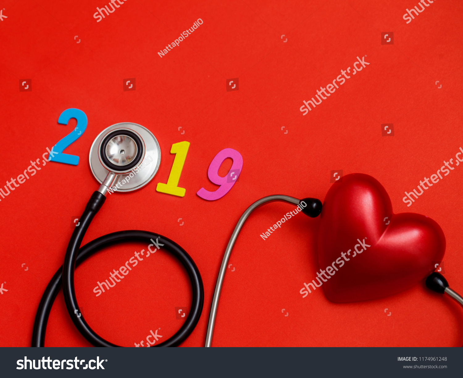 Wooden colorful on text 2019 banner for health care and Red heart love medical concept. black stethoscope,on table red background. #1174961248