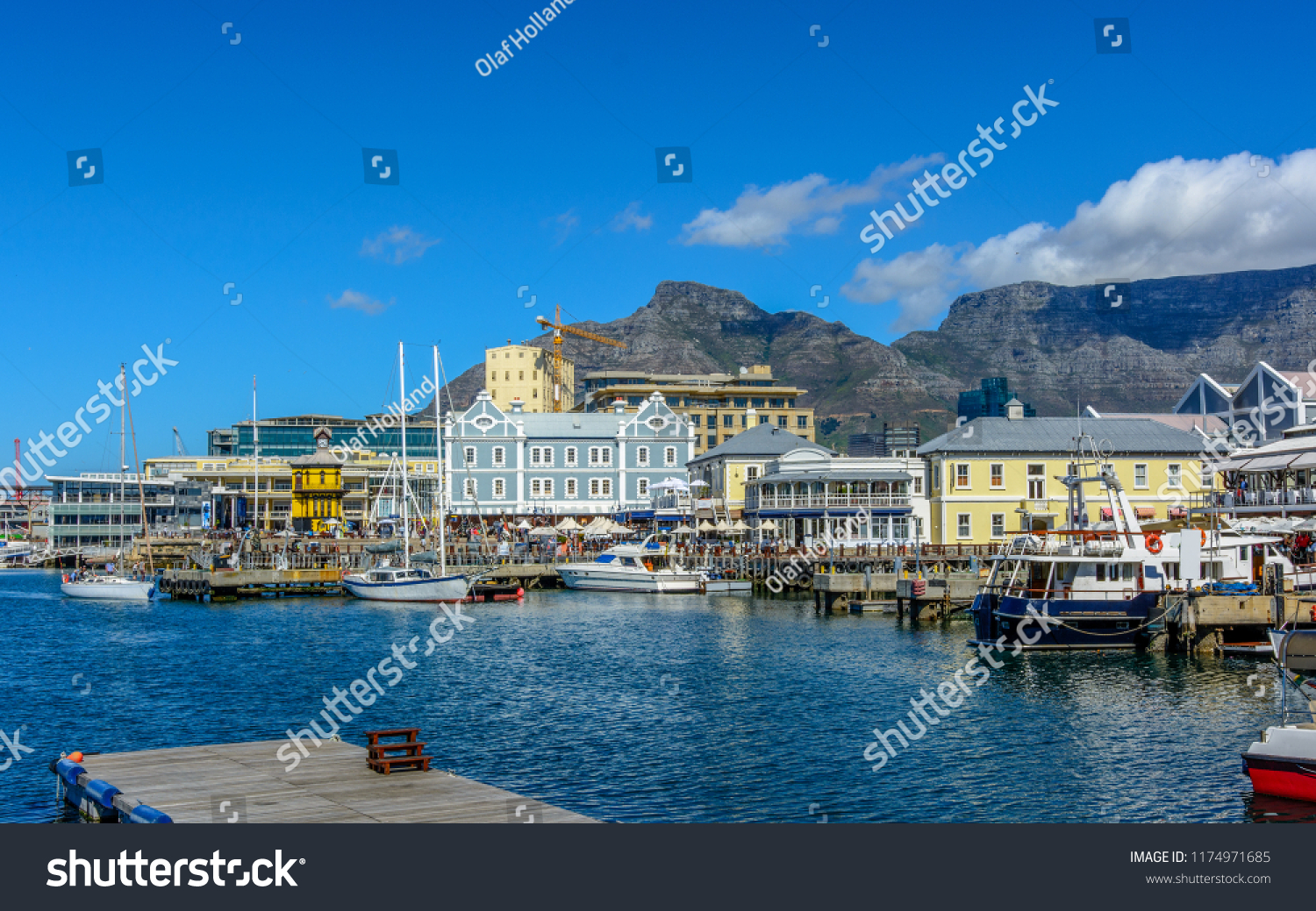 Bright color city and landscape panoramic view of the Table Mountain,Cape Town,South Africa, seen from V&A Waterfront with clock tower,boats in the sea harbor,bright sunny day,blue sky,clouds 