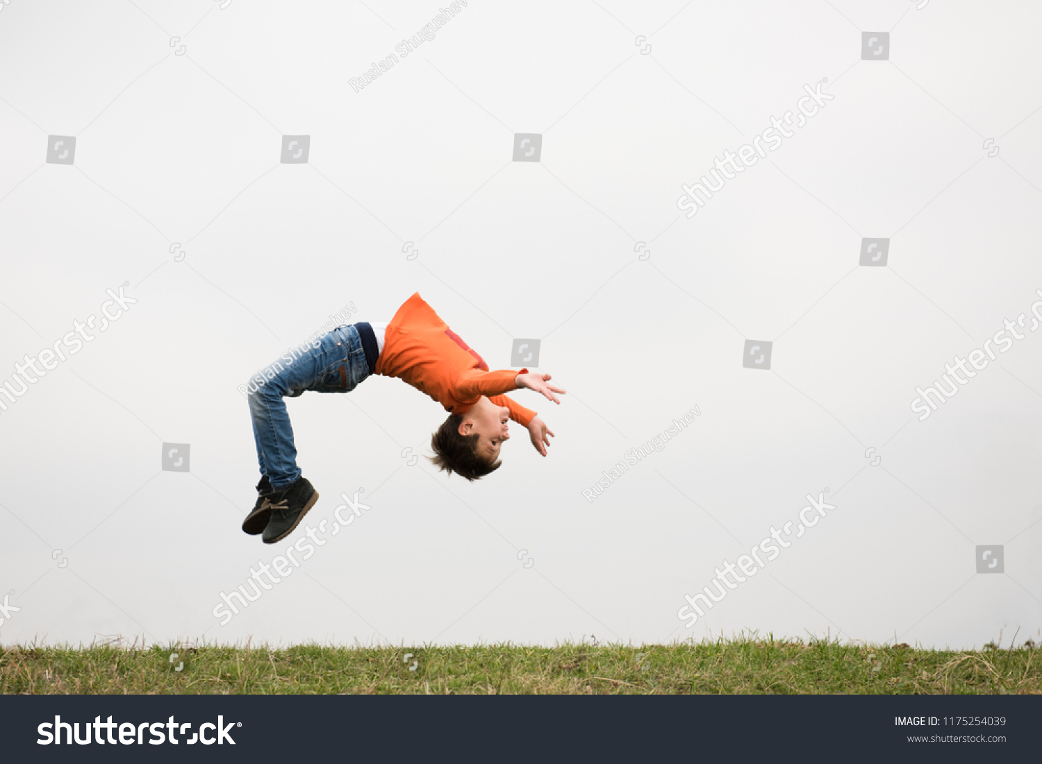 healthy sport little caucasian boy jumping somersault outdoors nature with copyspace #1175254039