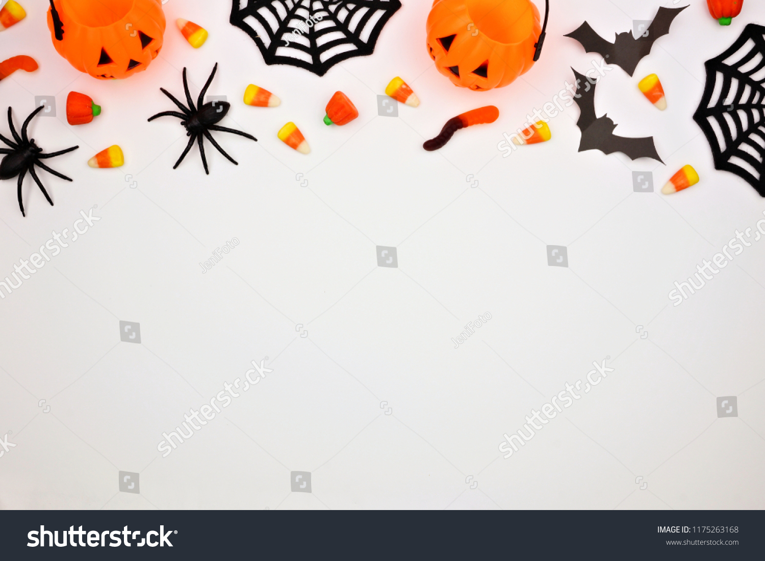 Halloween top border of scattered candy and decor. Flat lay over a white background. Copy space. #1175263168