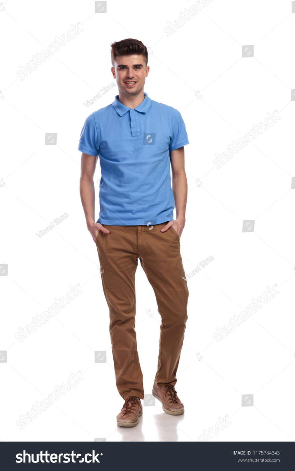 full body picture of a smiling casual man standing with hands in pockets on white background #1175784343