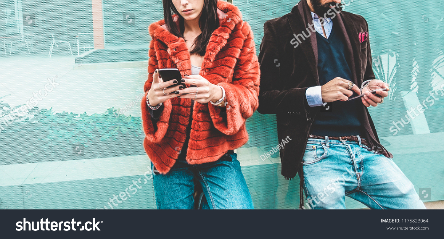 Trendy influencers people using smartphone social media app - Young fashion couple watching story video on mobile cell phone - Technology trends, marketing and new digital job concept - Focus on hands #1175823064