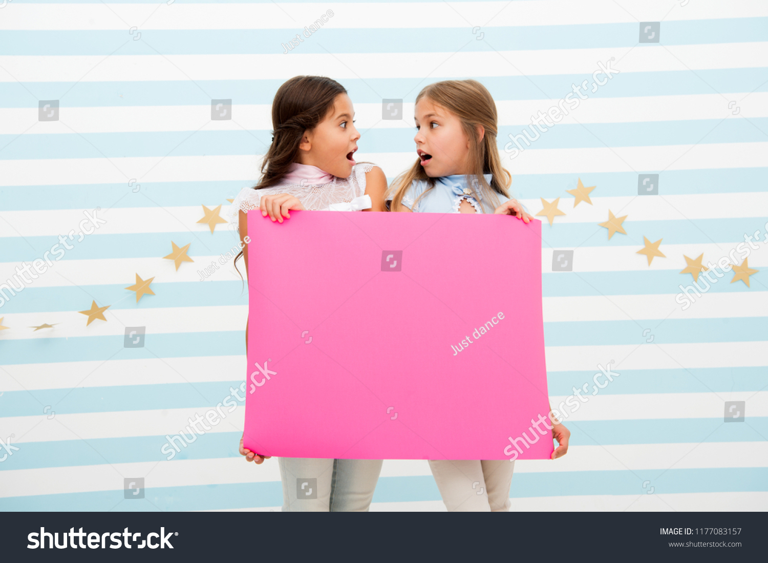 Shocking announcement concept. Amazing surprising news. Girl hold advertising banner. Girls kids holding paper banner for announcement. Shocked surprised children with blank paper copy space. #1177083157