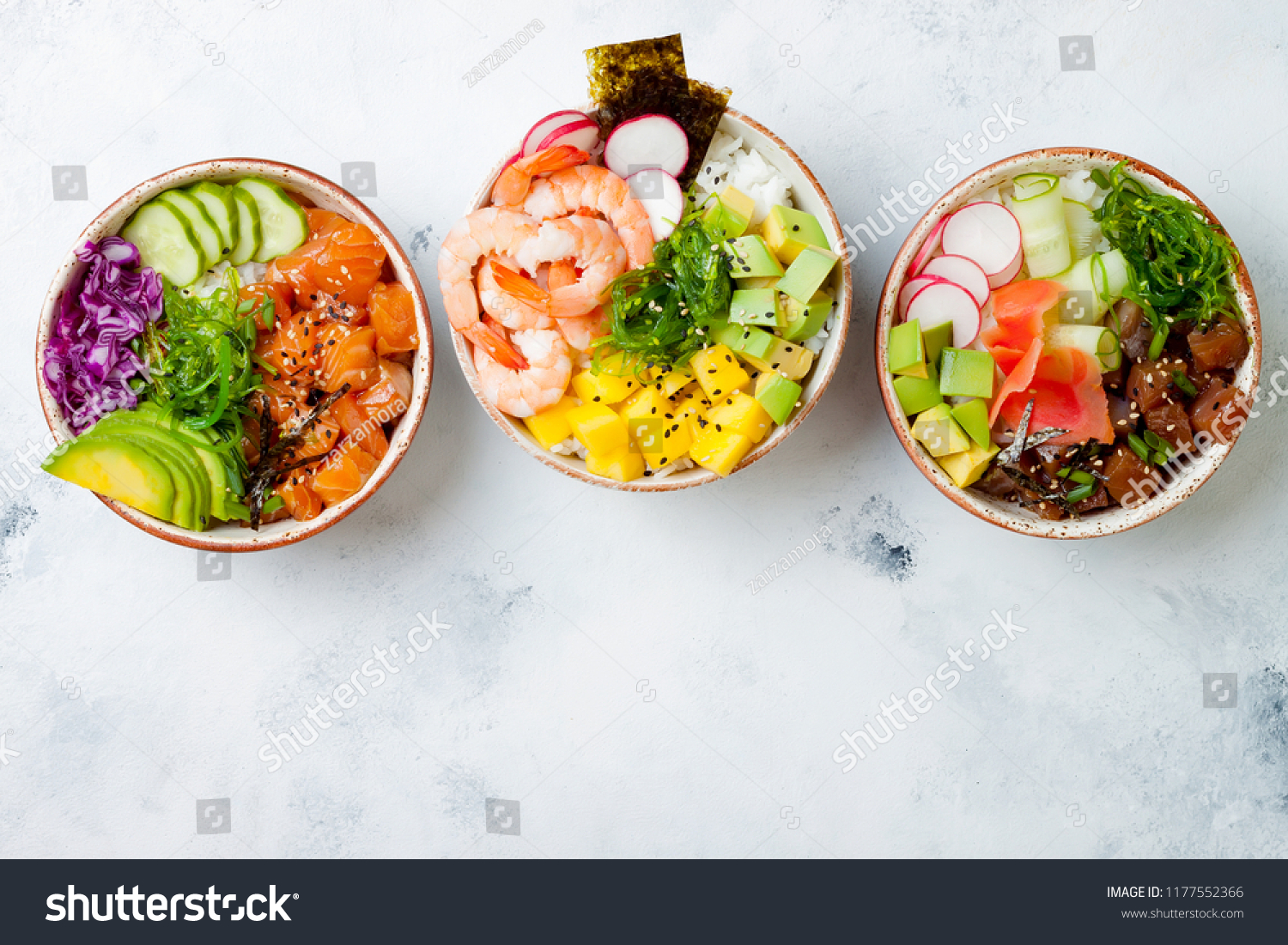 Hawaiian salmon, tuna and shrimp poke bowls with seaweed, avocado, mango, pickled ginger, sesame seeds. Top view, overhead, flat lay, copy space #1177552366