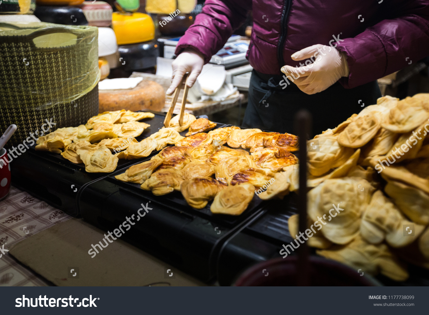 Theme is traditional street food in a European city on the market square in the Czech Republic Prague in the New Year's Eve, Christmas Eve festivities. Hands sell, prepare smoked cheese. #1177738099