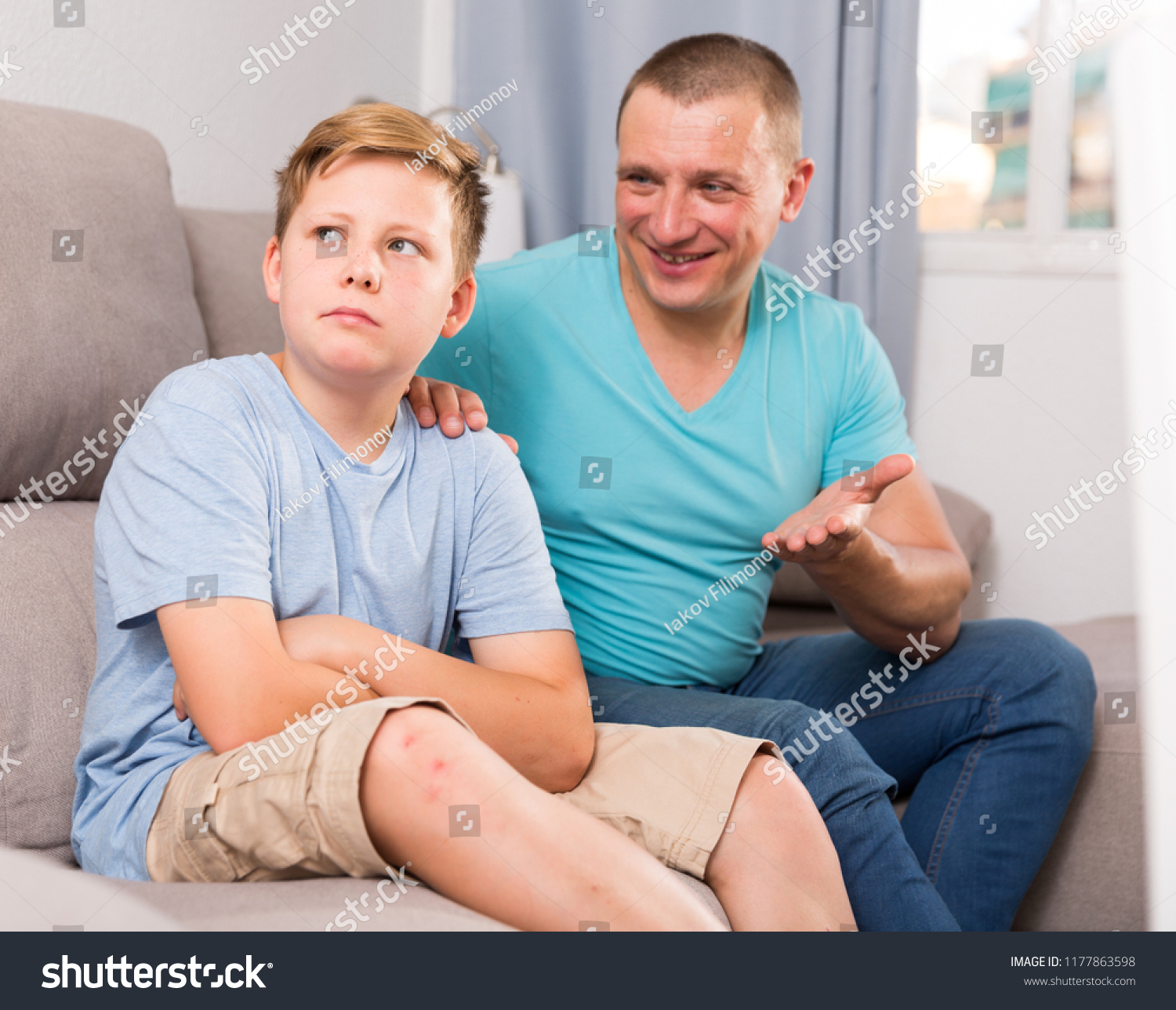 Boy is offended and father is asking for his forgiveness at the home. #1177863598