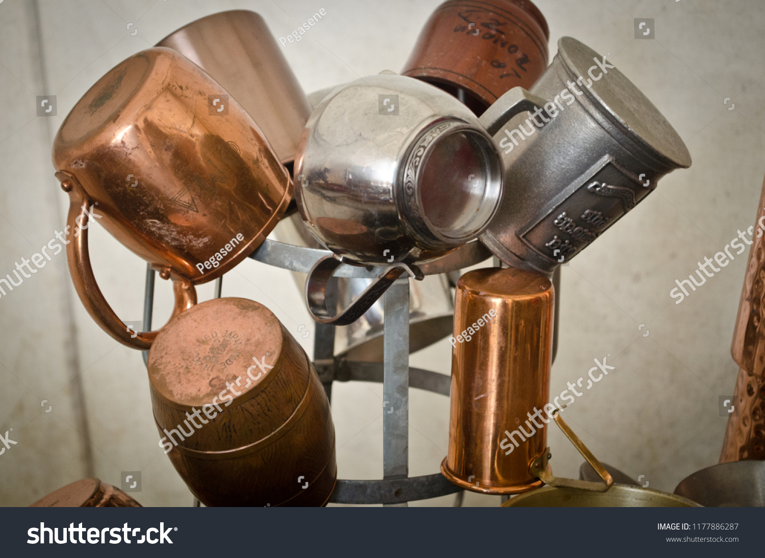 Display tree of pewter silver and copper cups tankards with a rustic white canvas background. #1177886287