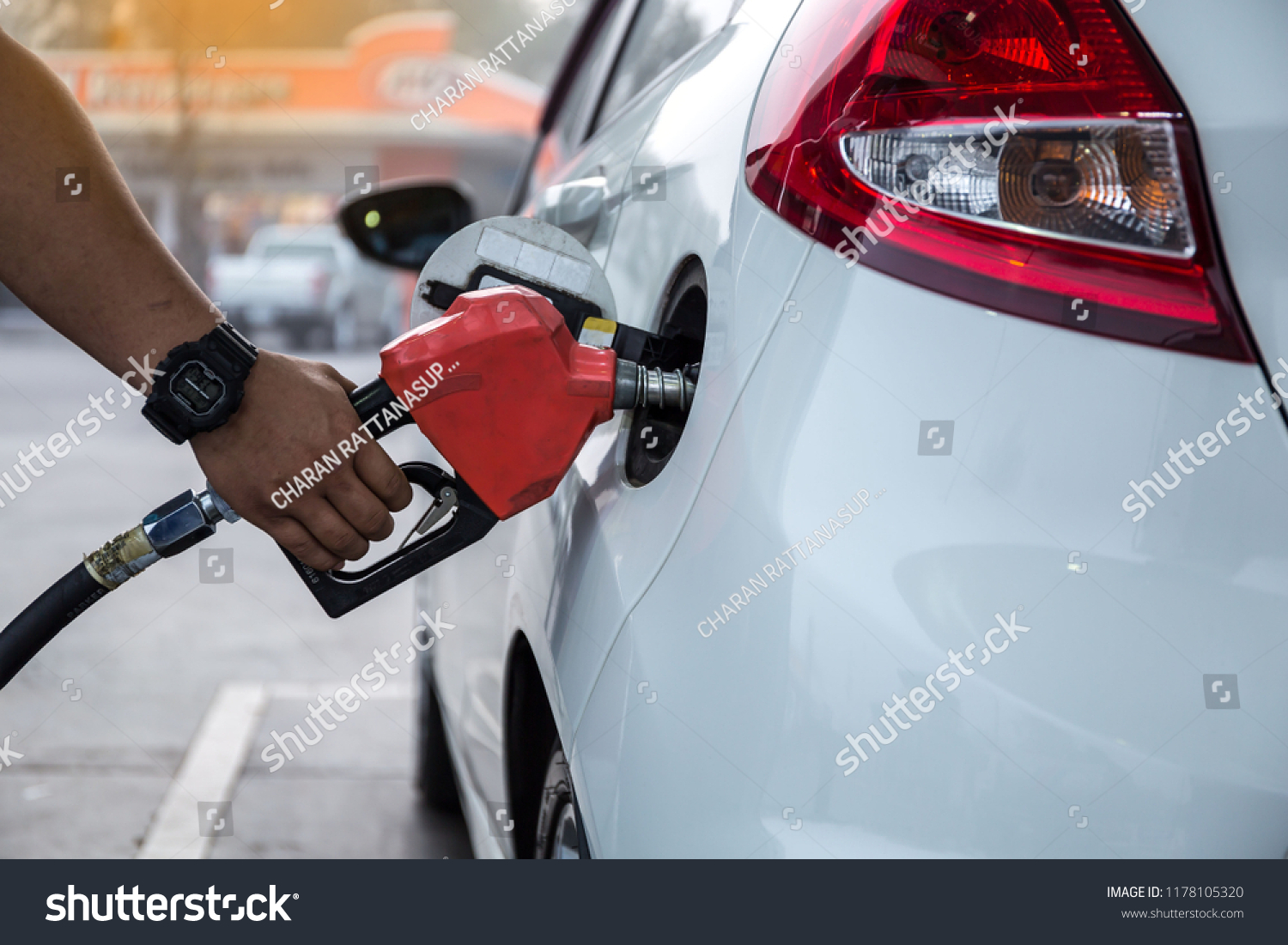 Closeup of woman pumping gasoline fuel in car at gas station. Petrol or gasoline being pumped into a motor vehicle car.
 #1178105320