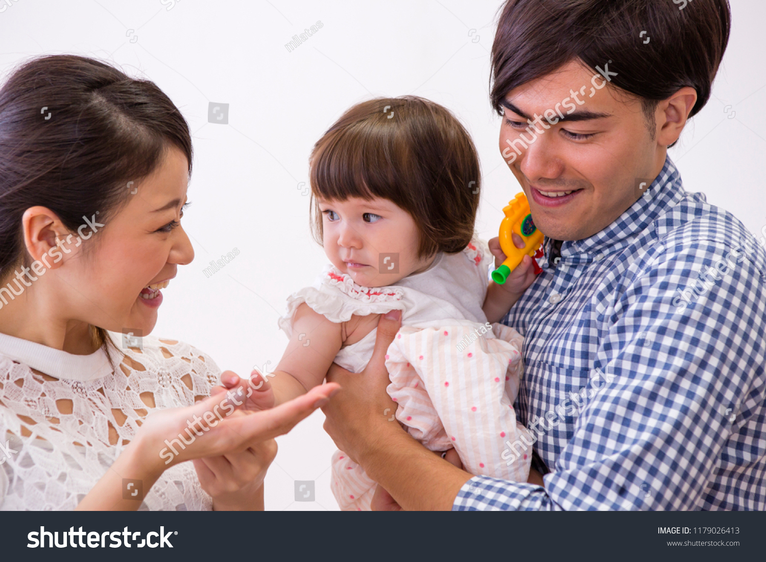 The girl who is held in their arm by parents #1179026413