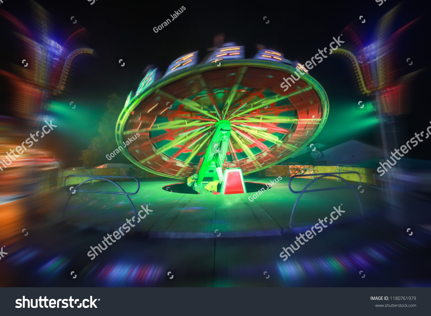 An illuminated rotating circular device in an amusement park with zoom in effect. #1180761979