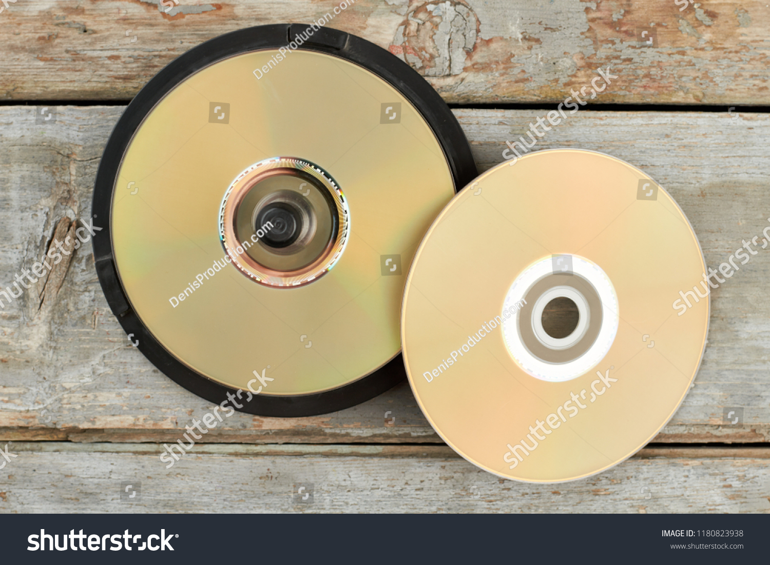 DVD discs on old wooden background. Stack of compact disks on rustic wooden surface. Outdated digital data storage. #1180823938