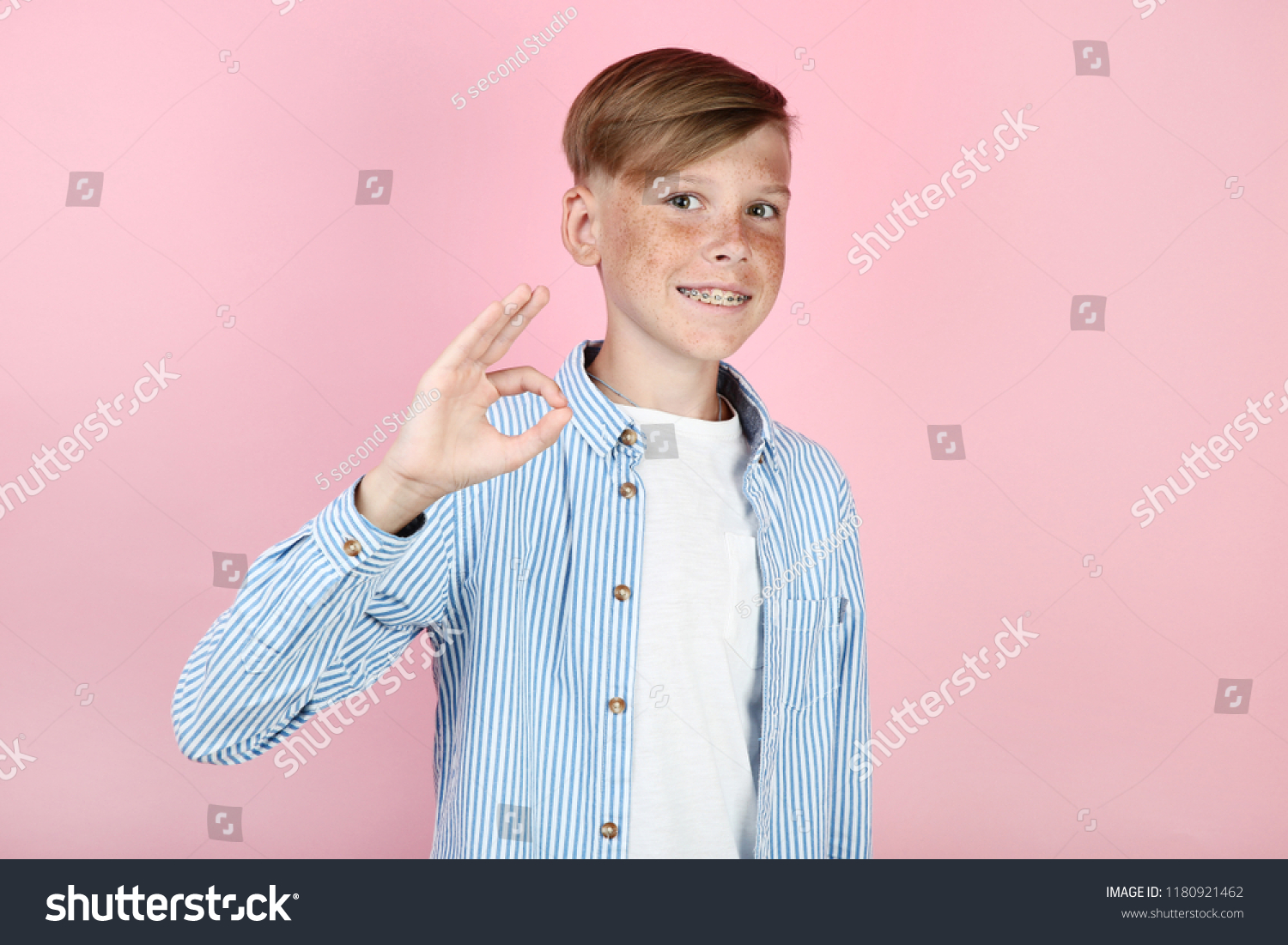Beautiful young boy with dental braces on pink background #1180921462