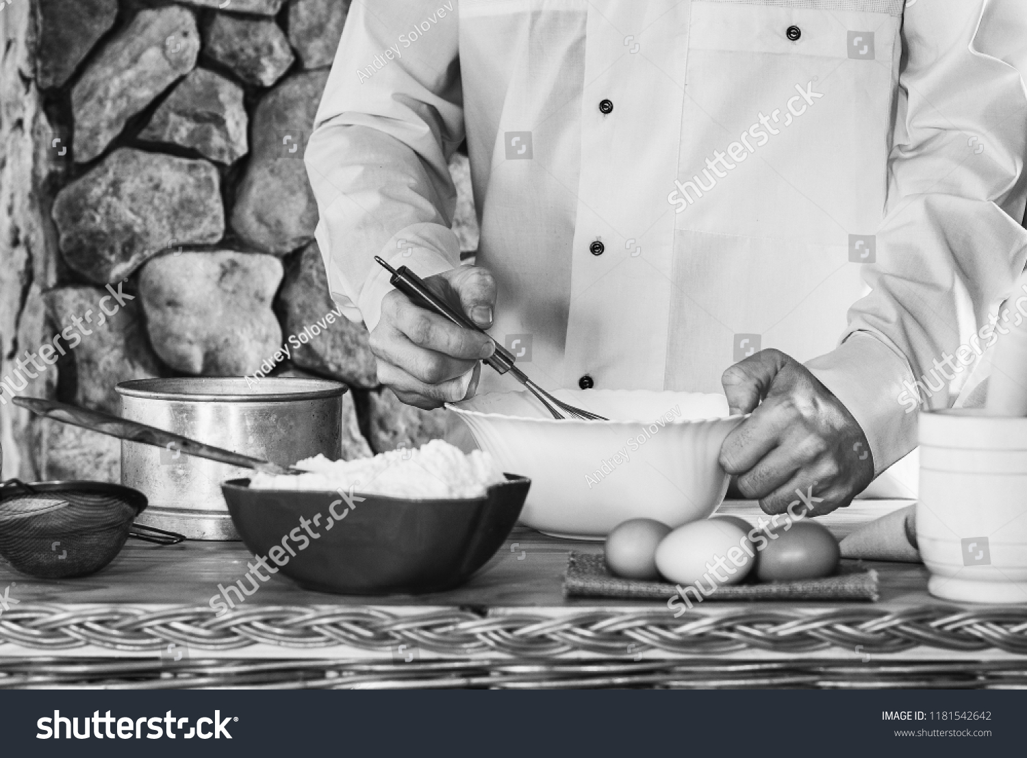 a male cook in a white garment whisk the whisk the batter, selective focus, black white photo #1181542642
