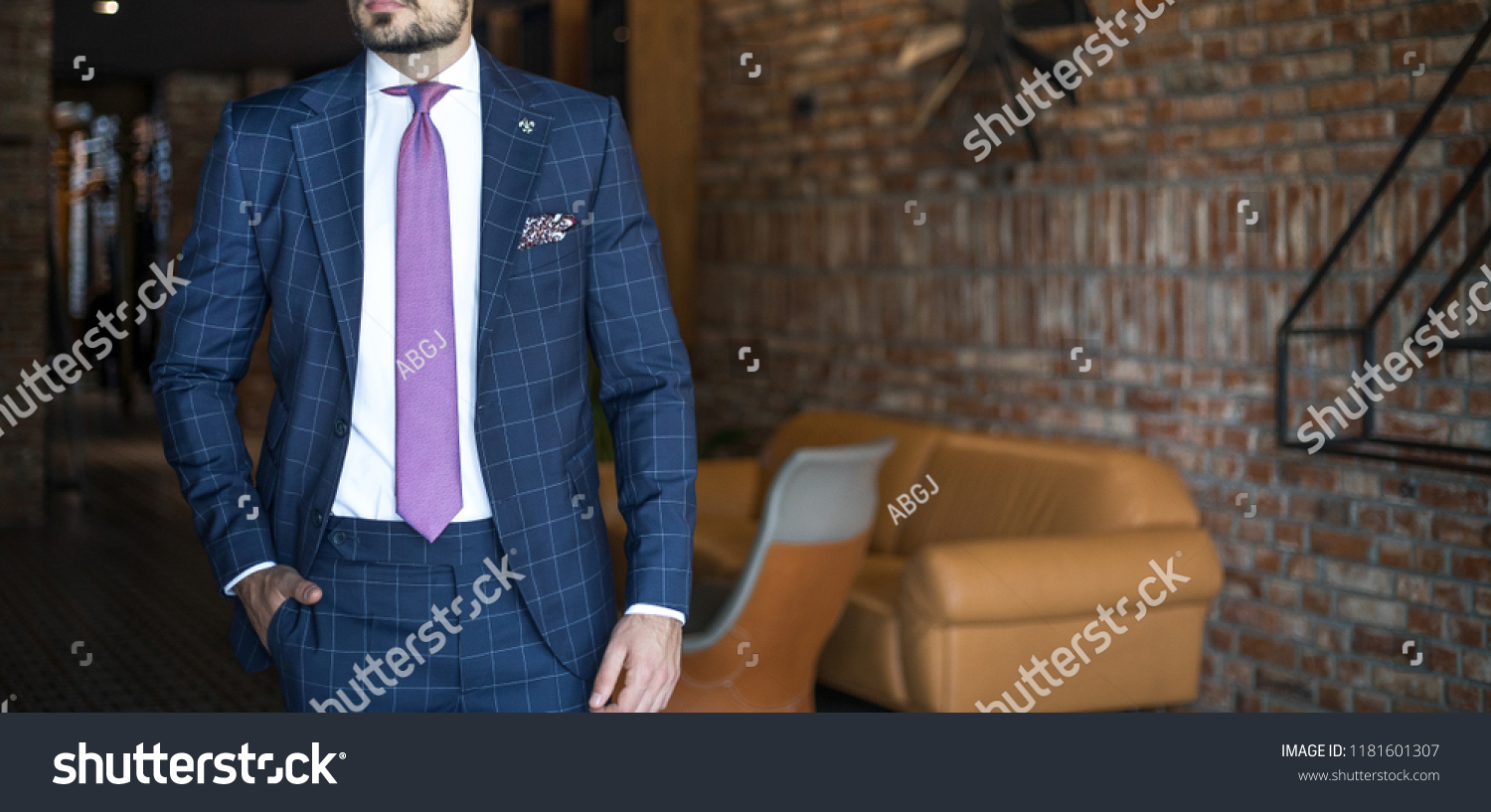 Man in expensive custom tailored suit posing indoors #1181601307