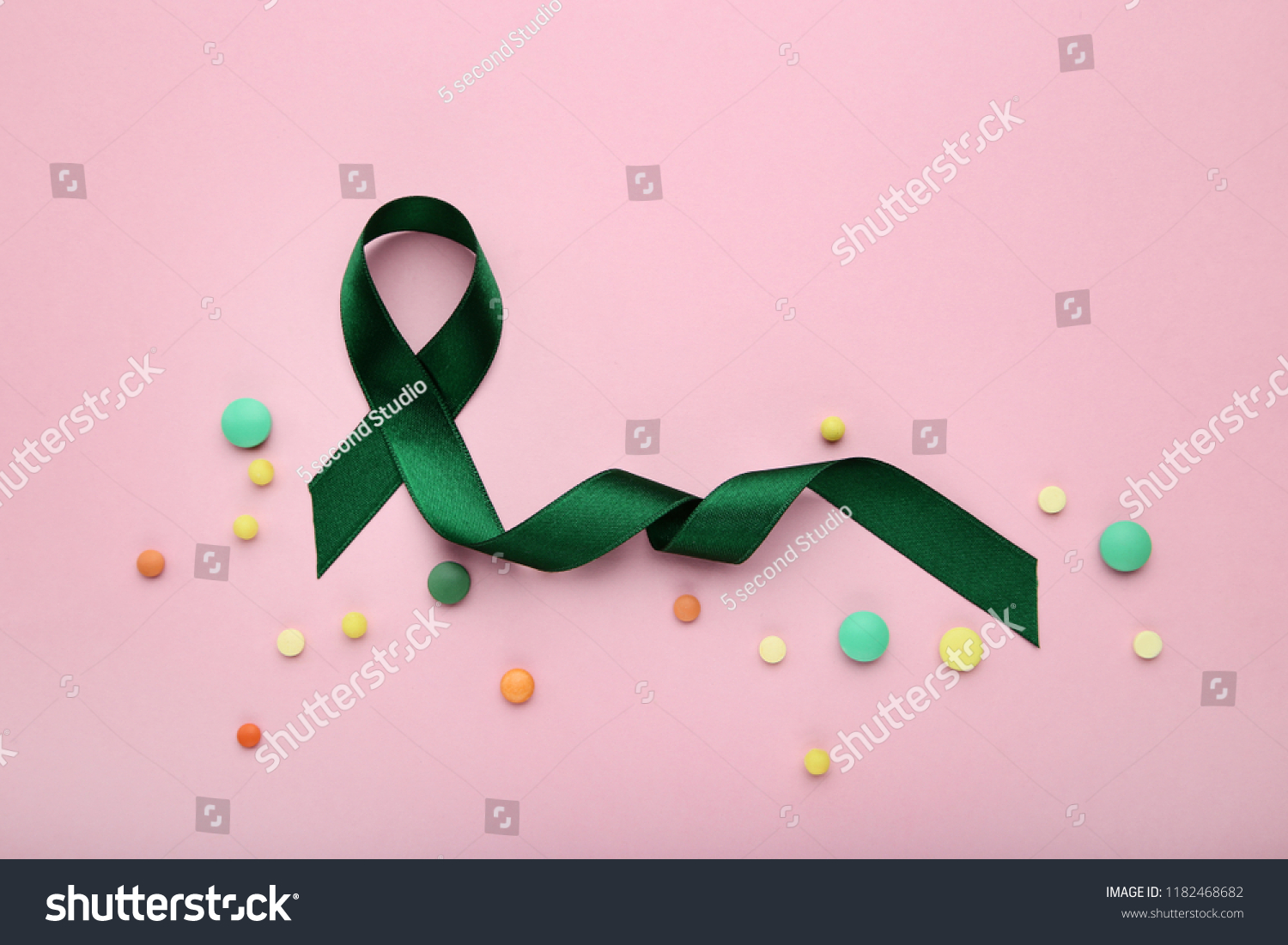 Green ribbon with colorful pills. Medical concept #1182468682