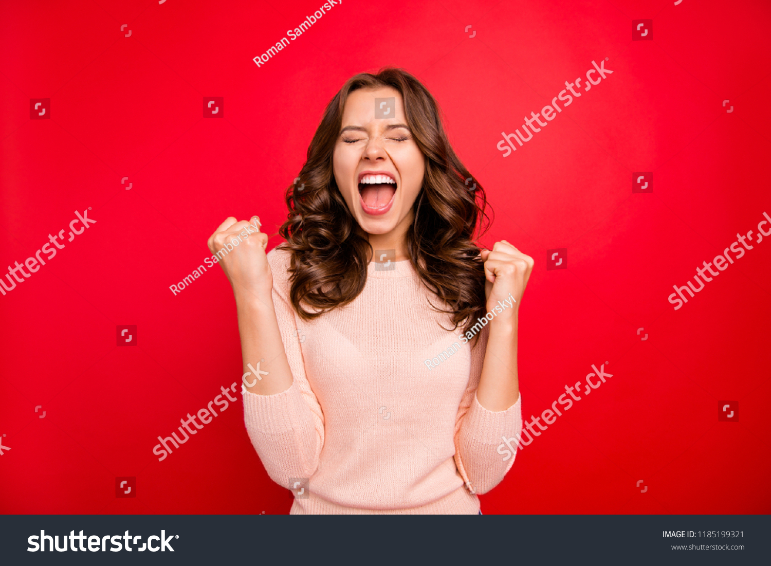 We did it! Portrait of closed eyes raised fists up woman in casual wear isolated on vivid red background with closed eyes and wide open mouth #1185199321