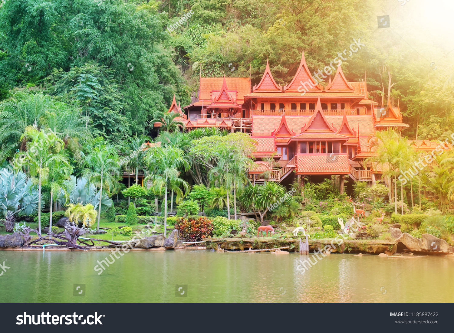 The buildings within the temple of Thailand are many trees and the mountains are the background. Public Attractions in Thailand. Khao Wong Temple in Uthai Thani in Thailand. Flare. #1185887422