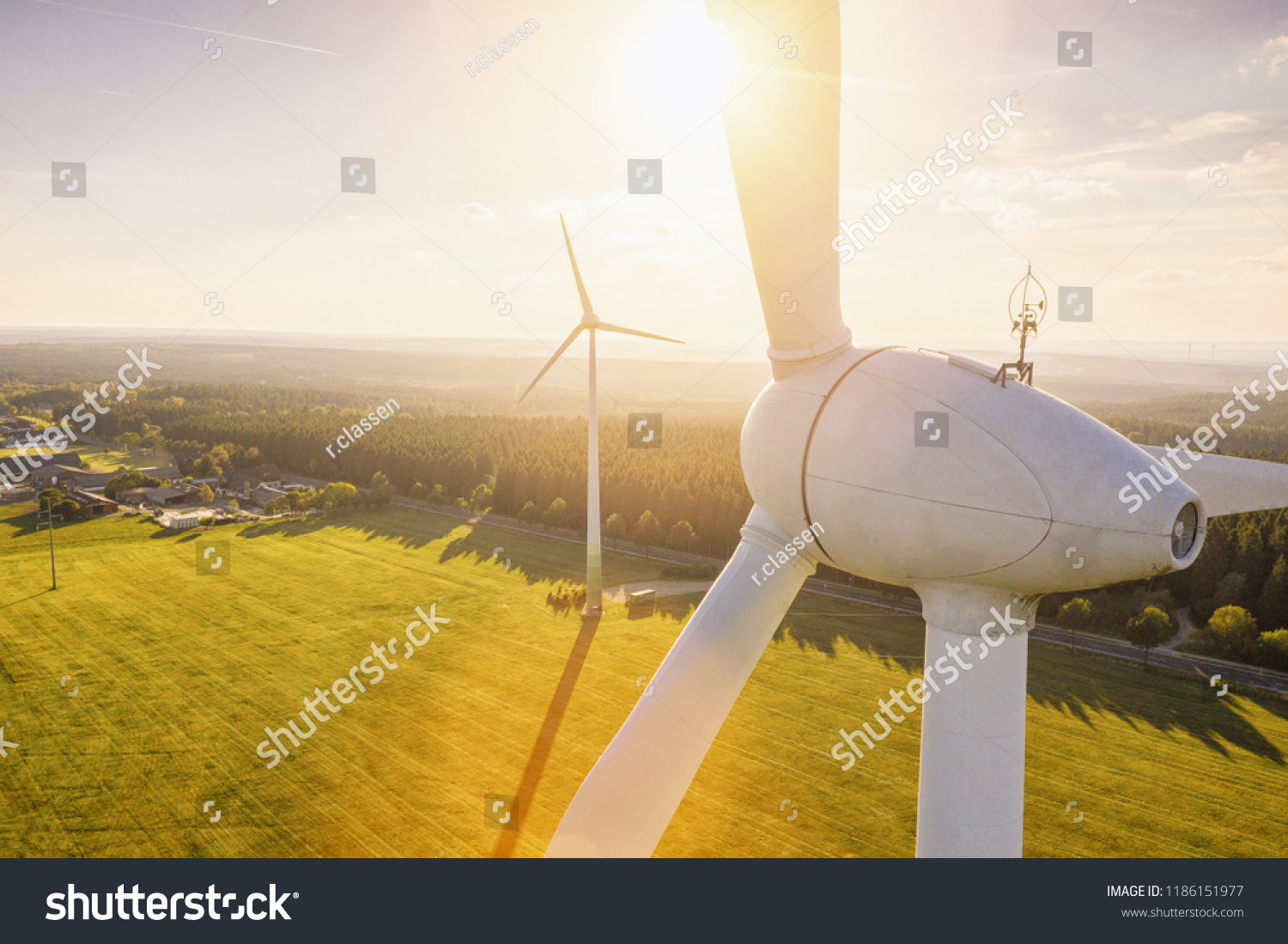Beautiful sunset above the windmills on the field #1186151977