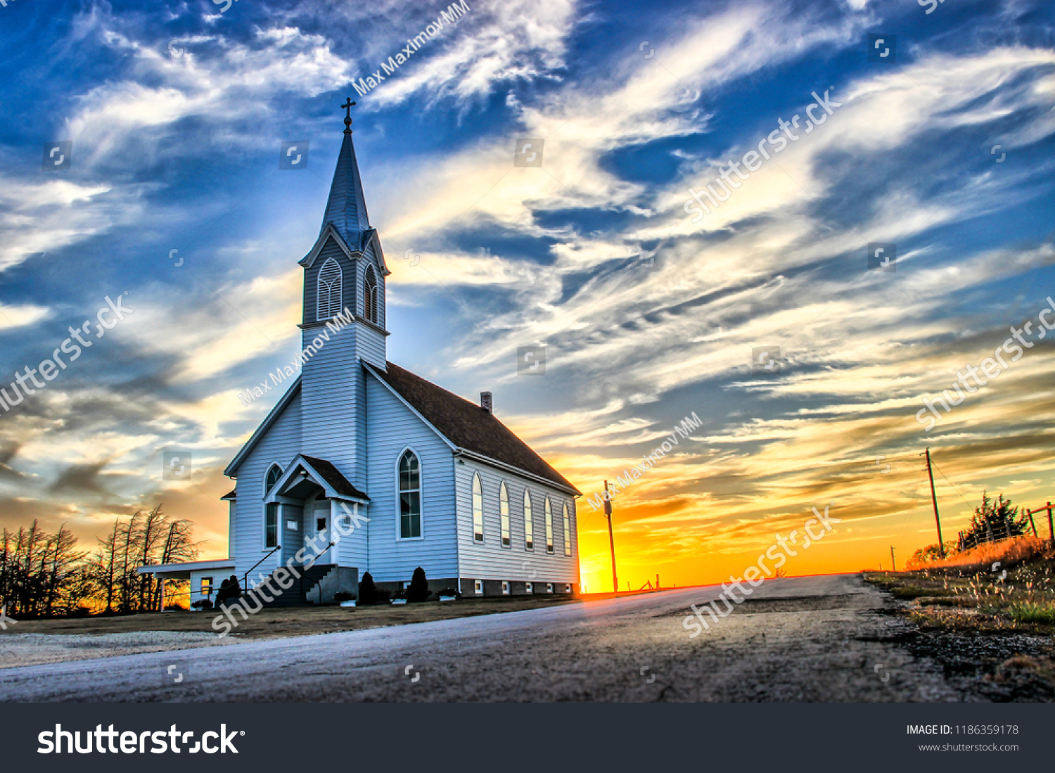 A Lone Wooden Church at Dusk with Sunset Clouds in Kansas American Midwest Prairie #1186359178