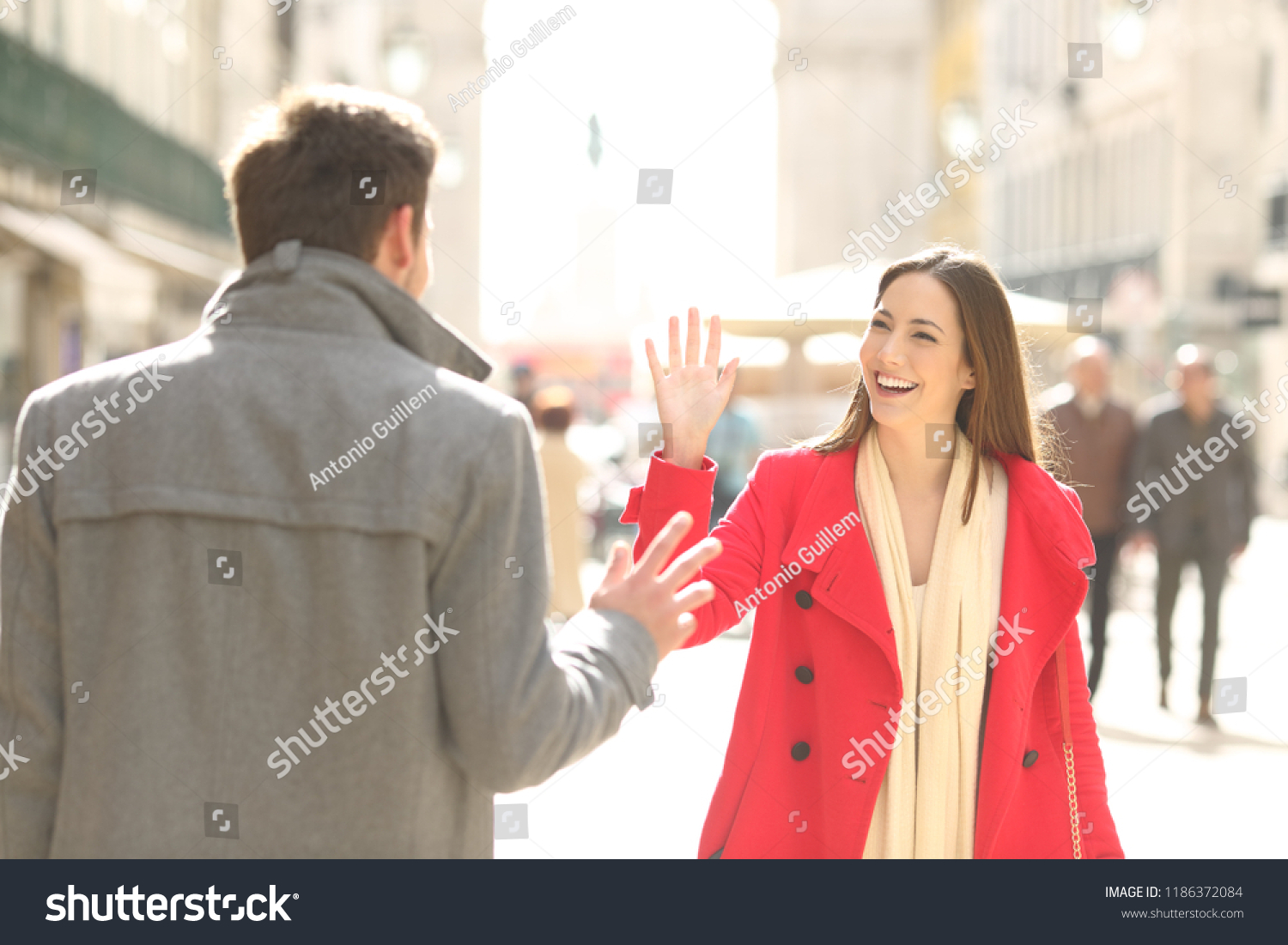 Two happy friends meeting and greeting in the street of a big city #1186372084