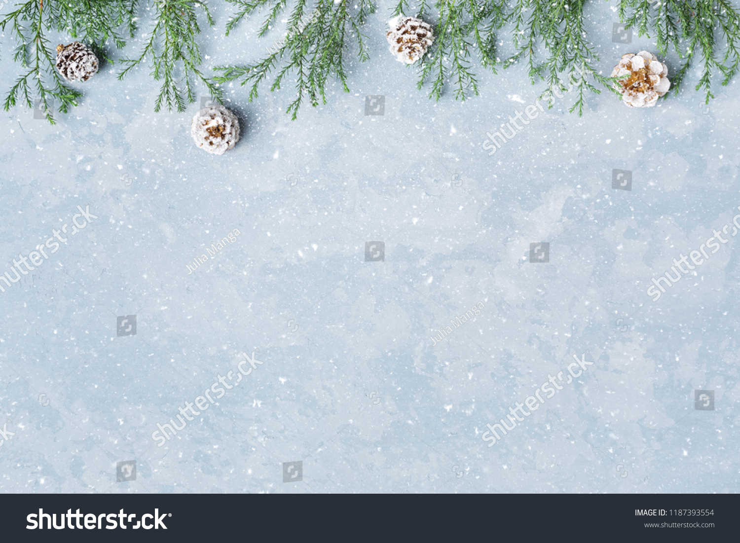 Christmas and New Year snowy background. Green twigs, cones border. Blue copy space. Winter holidays. #1187393554