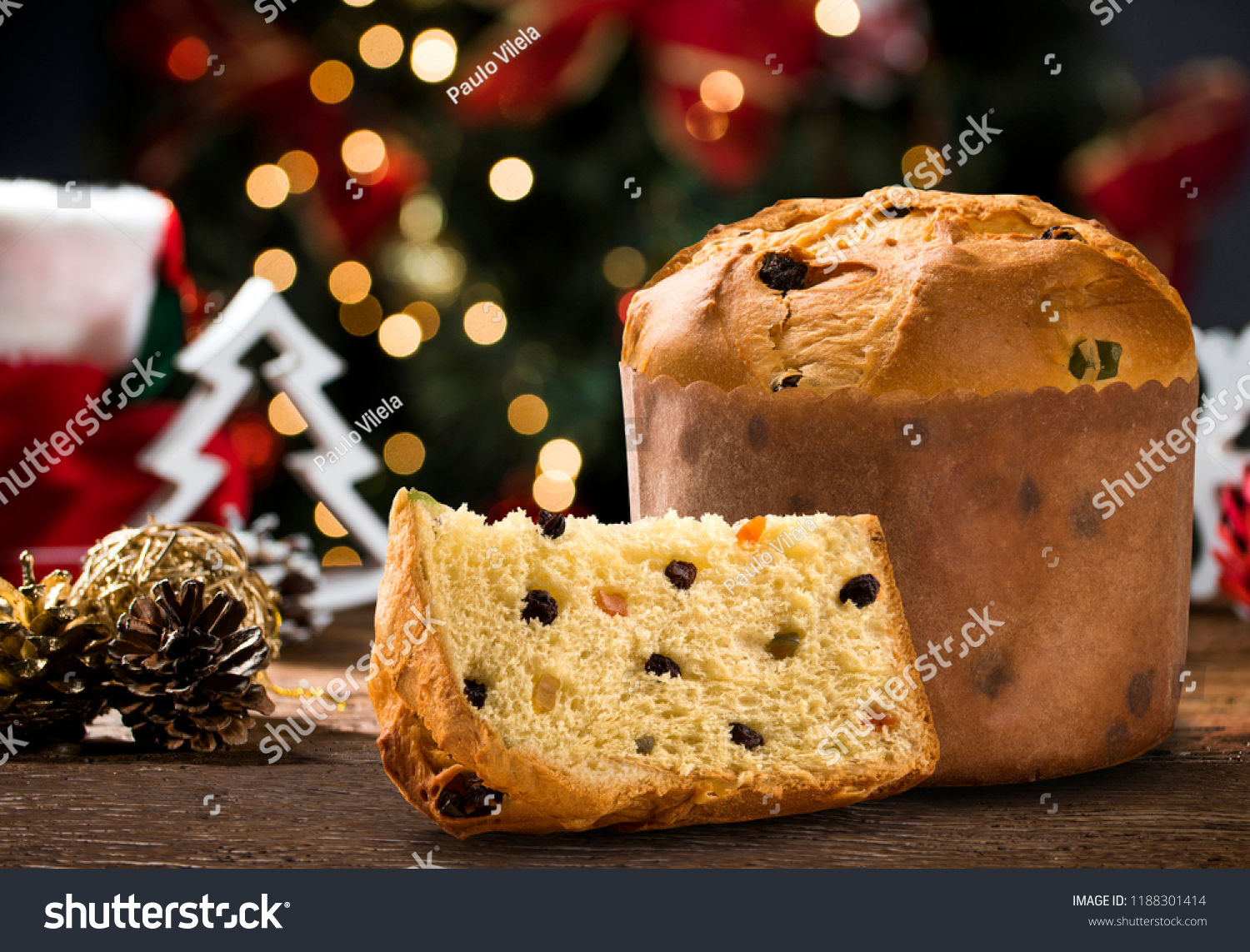 Delicious Panettone slice with candied fruits with blinking blurred christmas lights. #1188301414