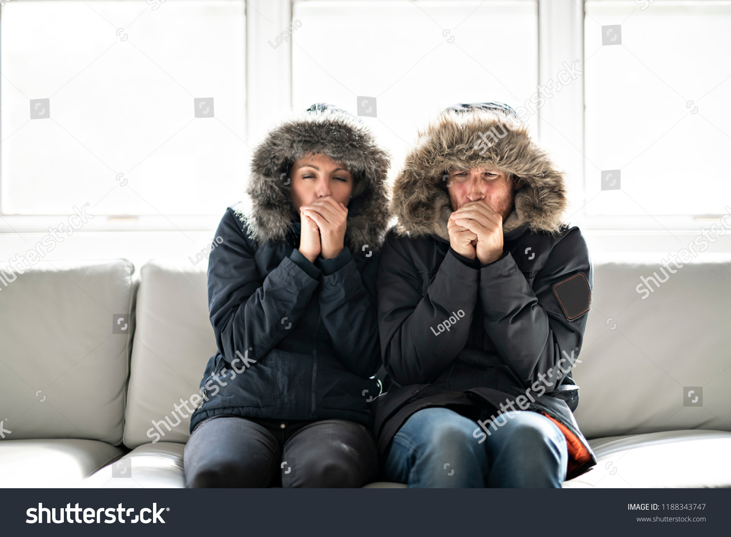 Couple have cold on the sofa at home with winter coat #1188343747