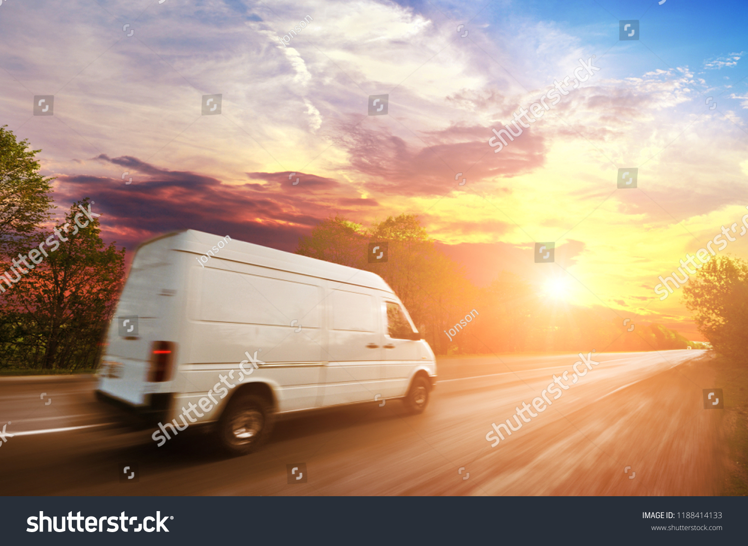 Big white van in motion on the countryside road shipping goods against night sky with sunset #1188414133