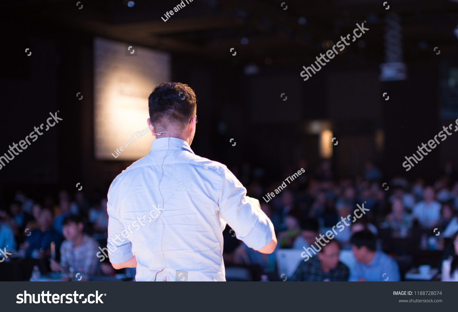 Presenter Presenting Presentation to Audience. Defocused Blurred Conference Meeting People. Lecturer on Stage. Speaker Giving Speech to Business and Technology Industry People. #1188728074