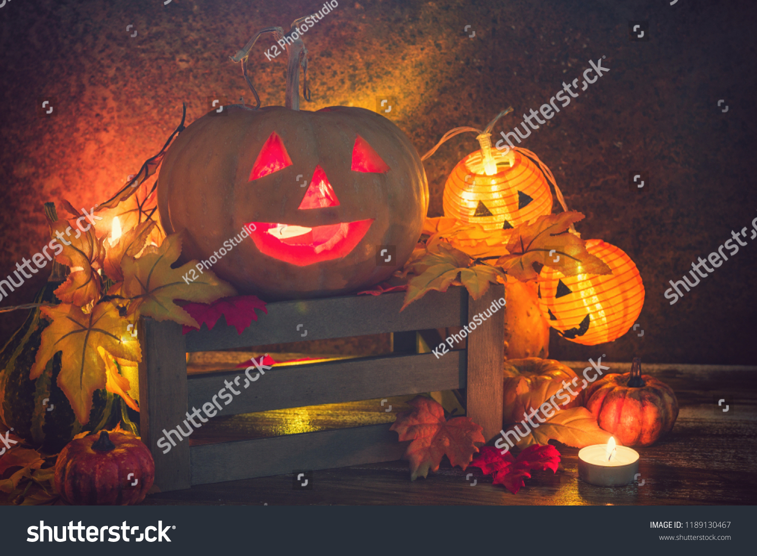 Jack O’ Lanterns glowing on the old rustic background #1189130467