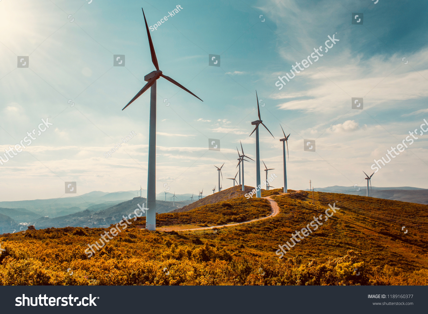 Wind turbines on beautiful sunny summer autumn mountain landsape. Curvy road through mountain Eolic park. Green ecological power energy generation. Wind farm eco field #1189160377