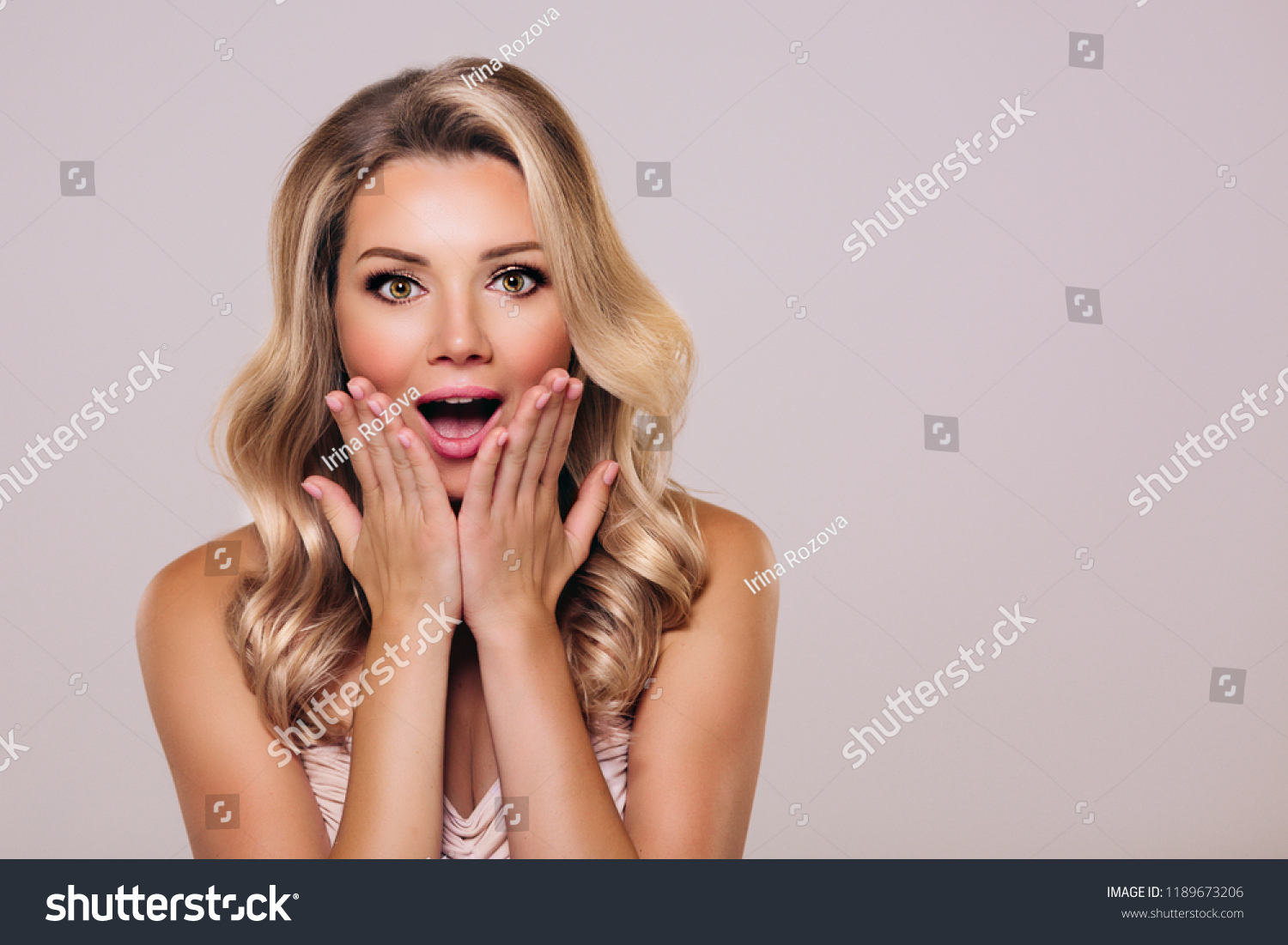 Surprised beautyful woman with opened mouth and blond hair. Woman in shock. Surprising facial emotions #1189673206