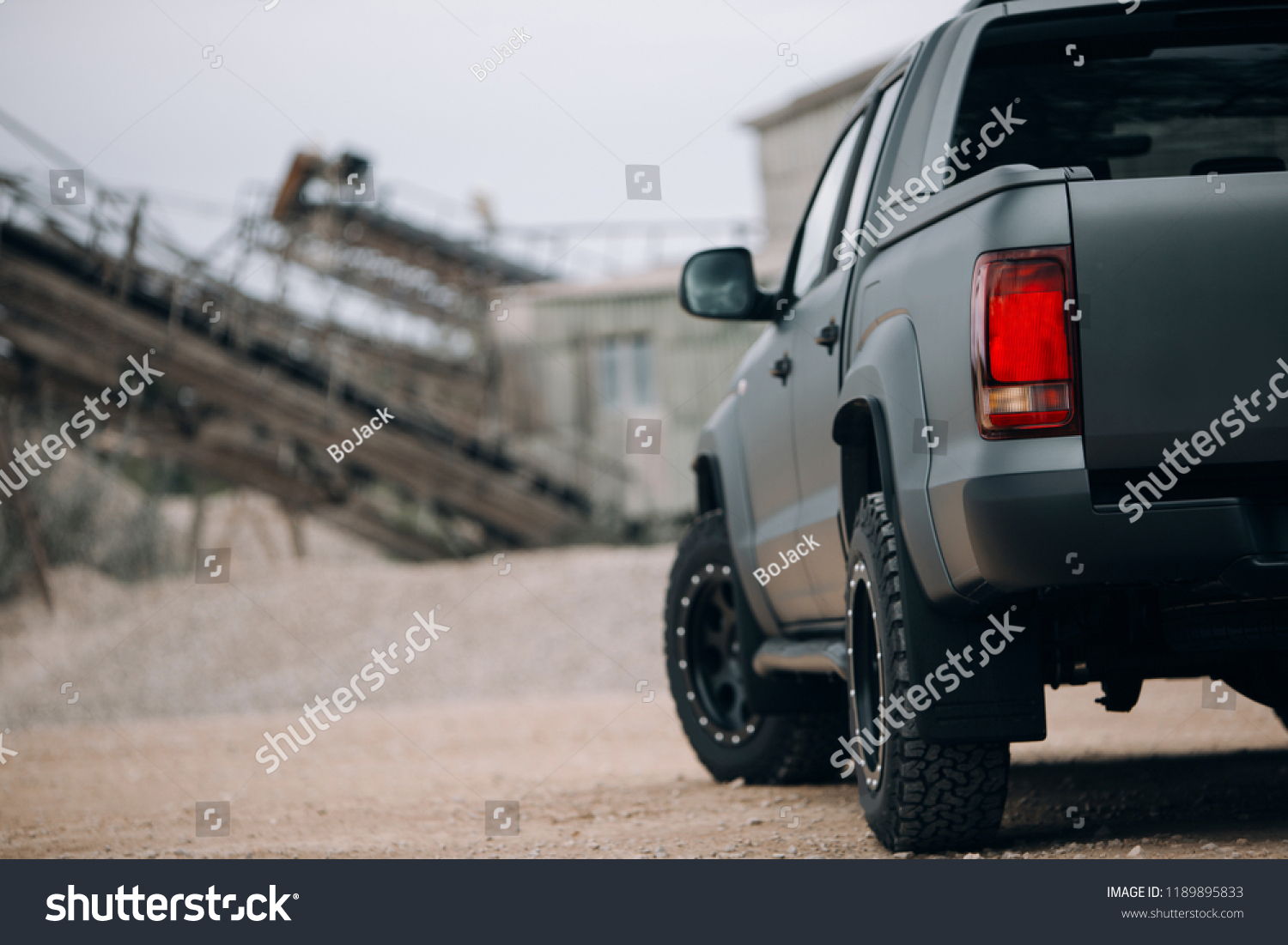 Pick up SUV car at the gravel carrier. Back view of the truck on the rural road. The army truck is stopped at the gravel.  #1189895833
