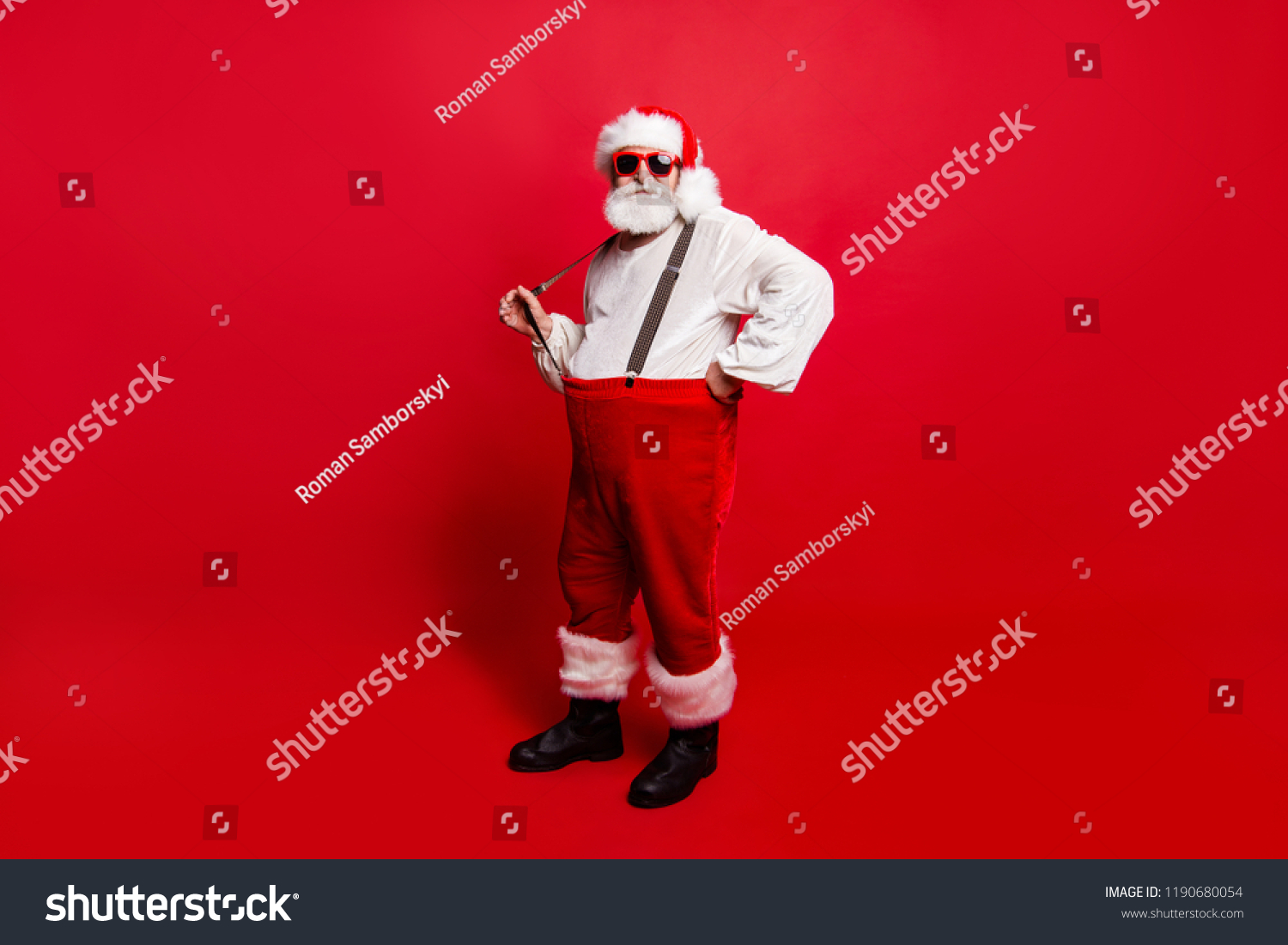 Full length body size of nice calm peaceful Santa pulling suspender preparing to feast festive party promo sale discount isolated over red background #1190680054