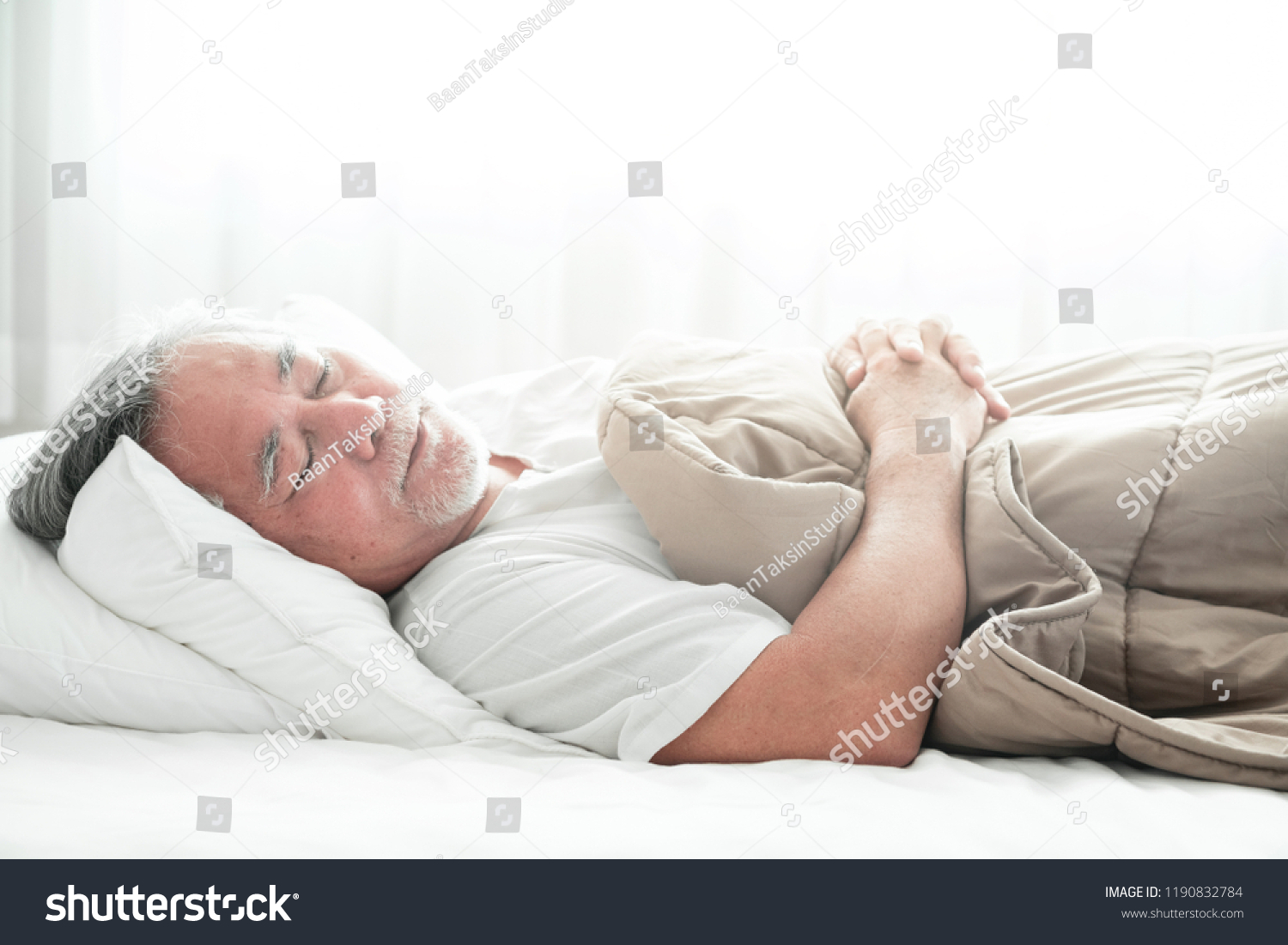 Senior man sleeping in bed. Old asian man sleeping comfortably in bed with curtain open. Senior lifesyle concept. #1190832784