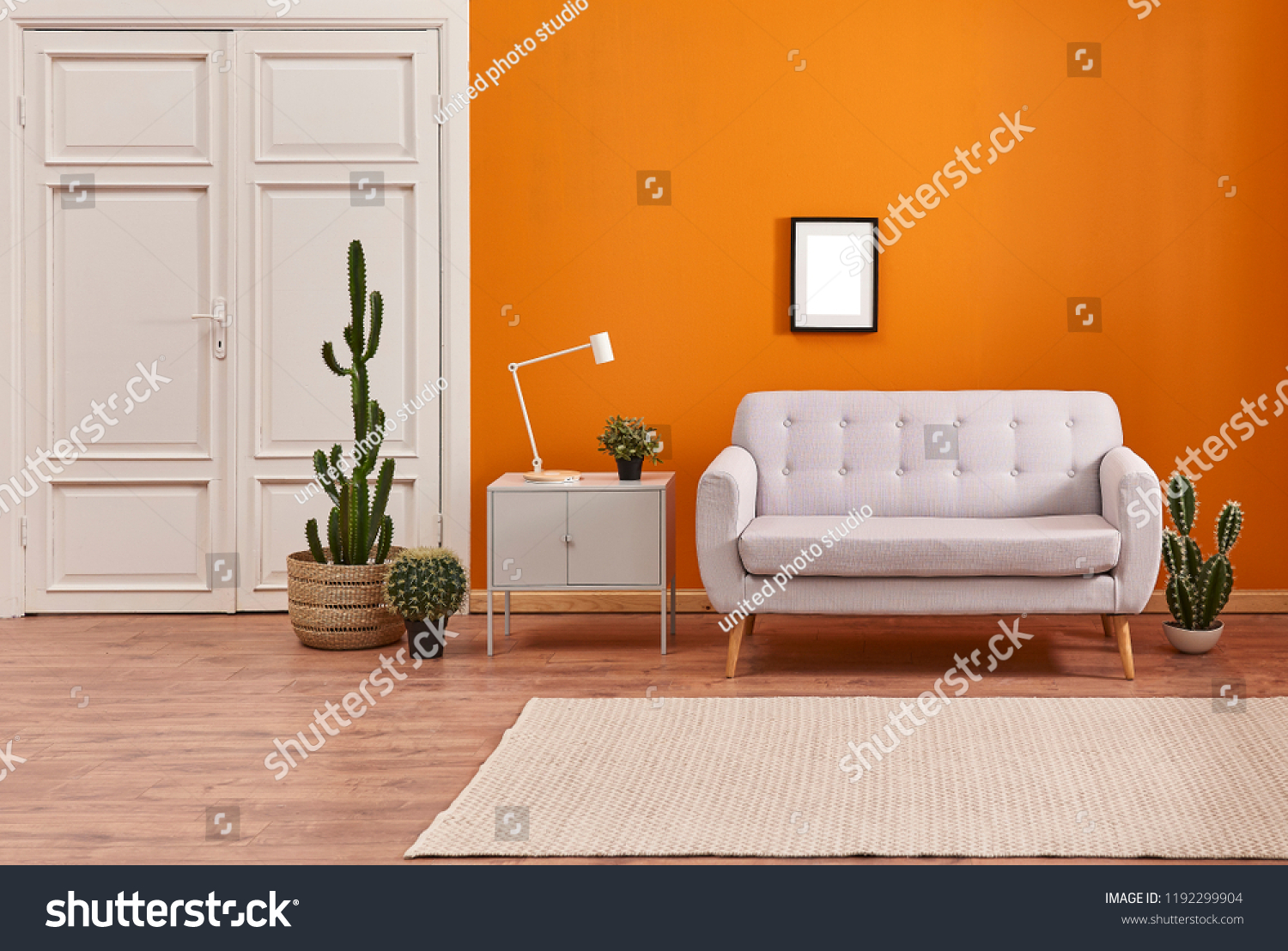 Orange living room and orange wall background light grey sofa and avangard white door. Modern home decoration brown parquet and carpet design. #1192299904
