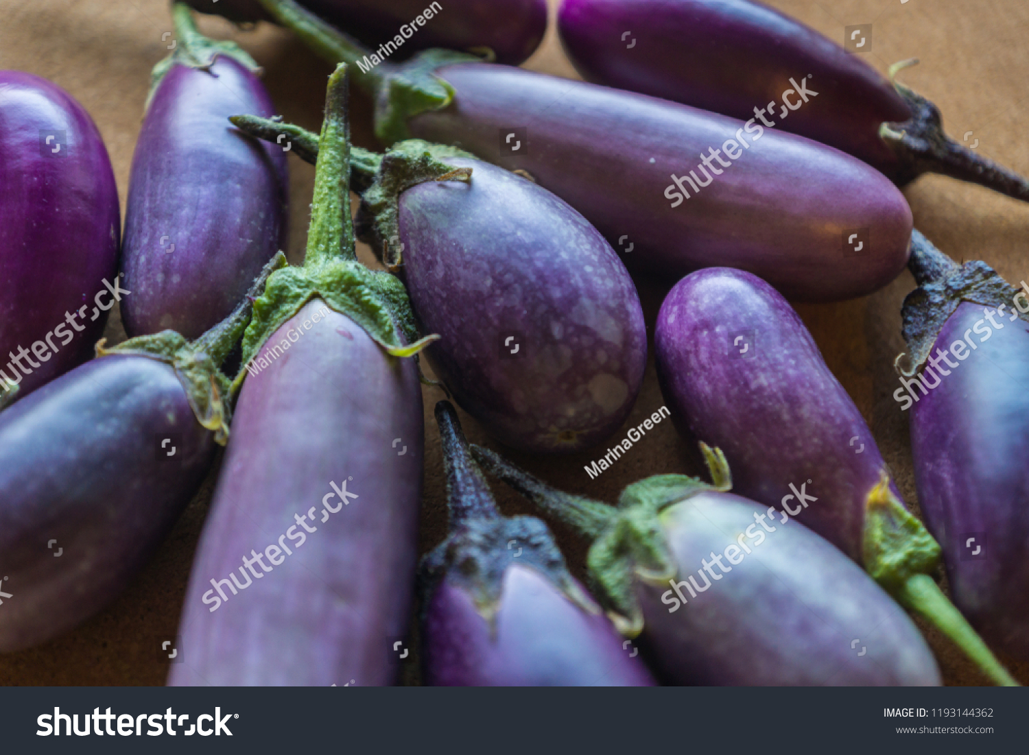 Shiny organic purple eggplants of dwarf heirloom variety Slim Jim from Italy, edible fruits of Aubergine plant grown in the city and harvested on the balcony as a part of urban gardening project #1193144362