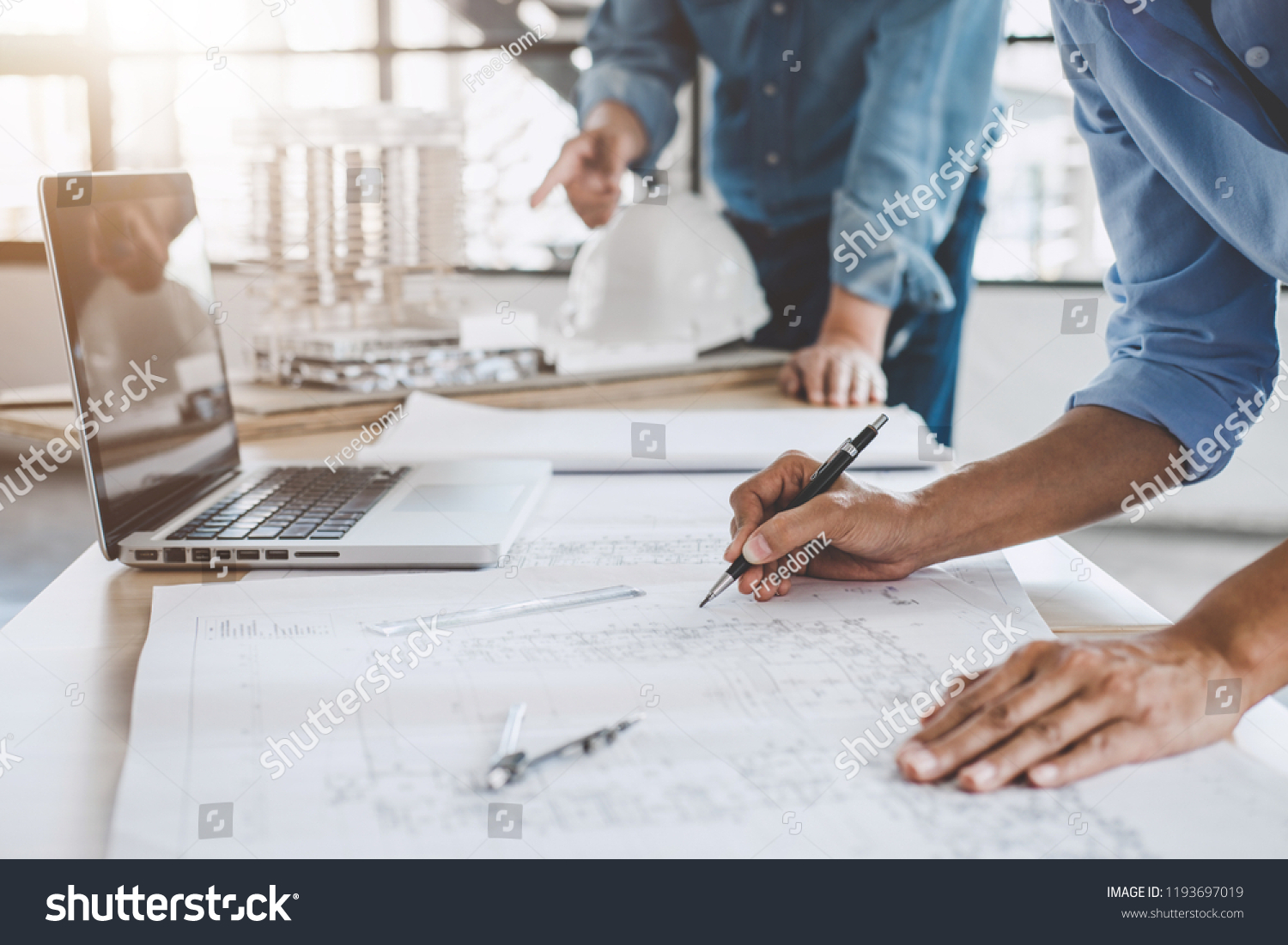 Construction concept of Engineer or architect meeting for project working with partner and engineering tools on model building and blueprint in working site. #1193697019