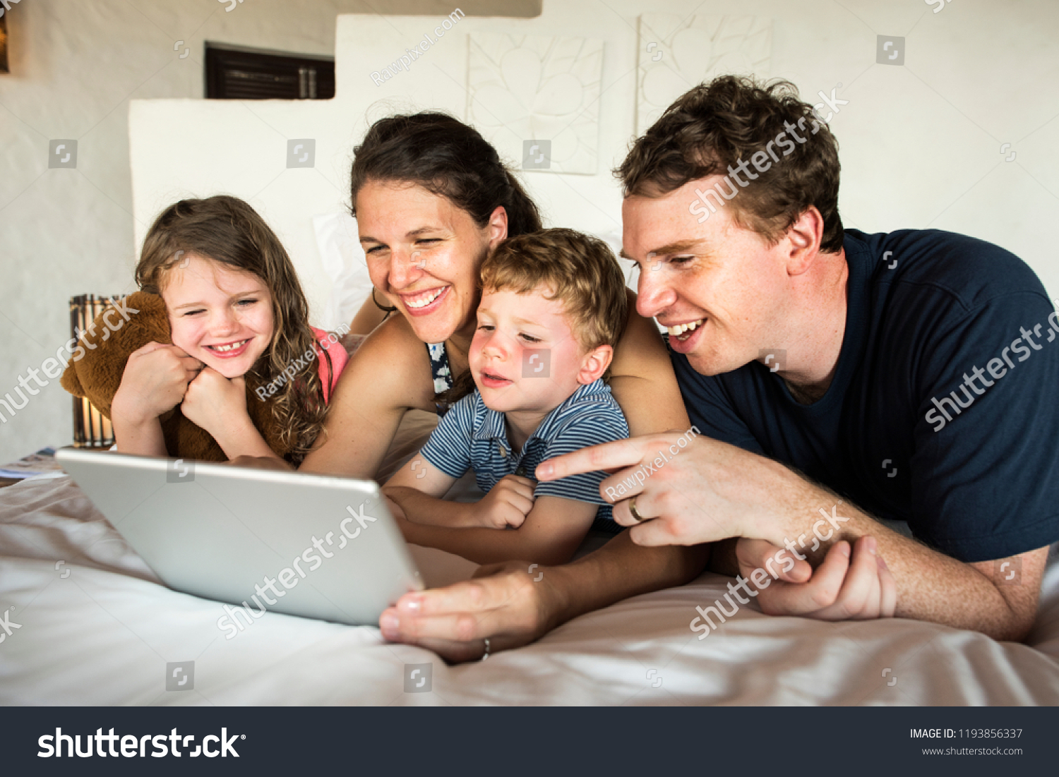 Family using a laptop in bed #1193856337