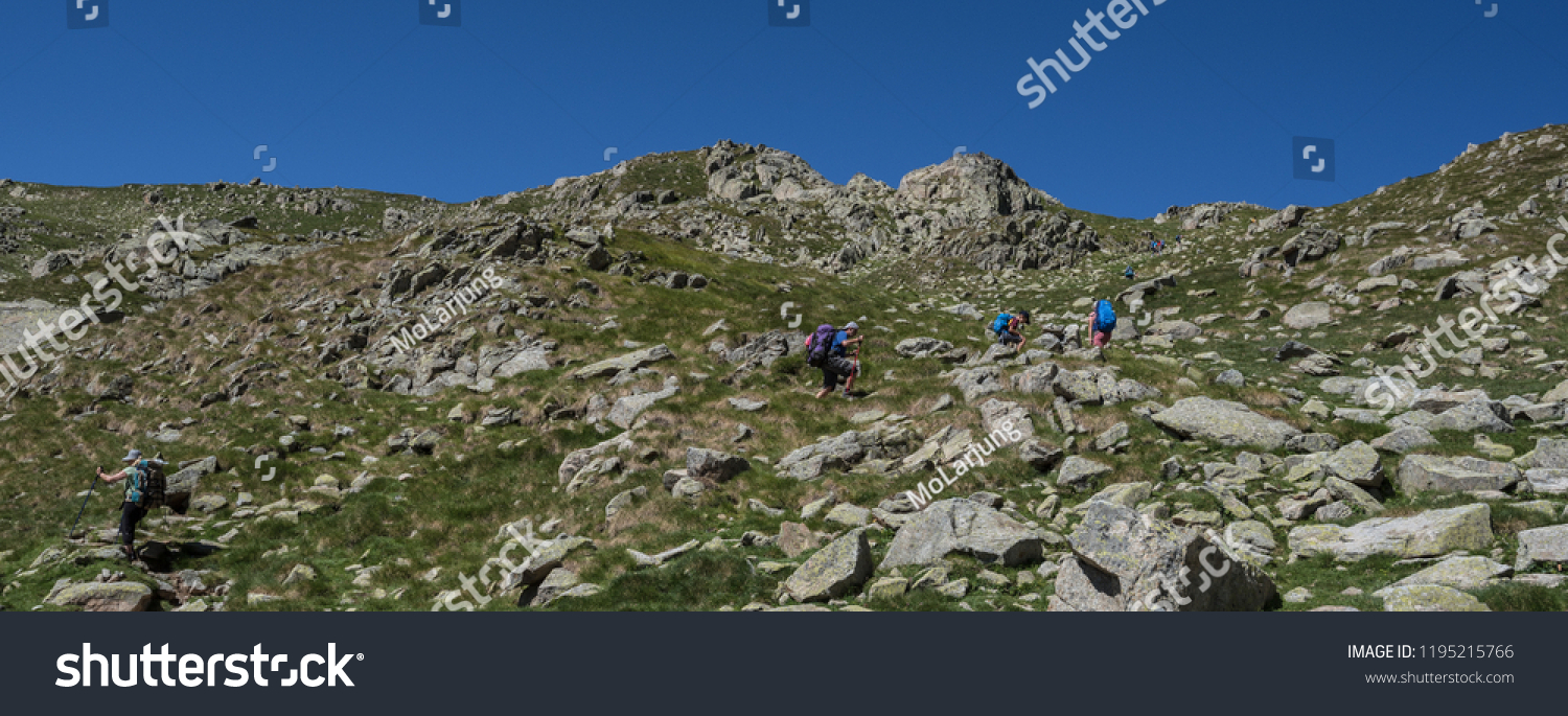 Trekkers on final ascent effort to Port de Caldes de Colomers mountain pass at 2,572 m ASL on trail GR11.18, Aiguestortes & Estany de Sant Maurici National Park, Pyrenees, Spain #1195215766