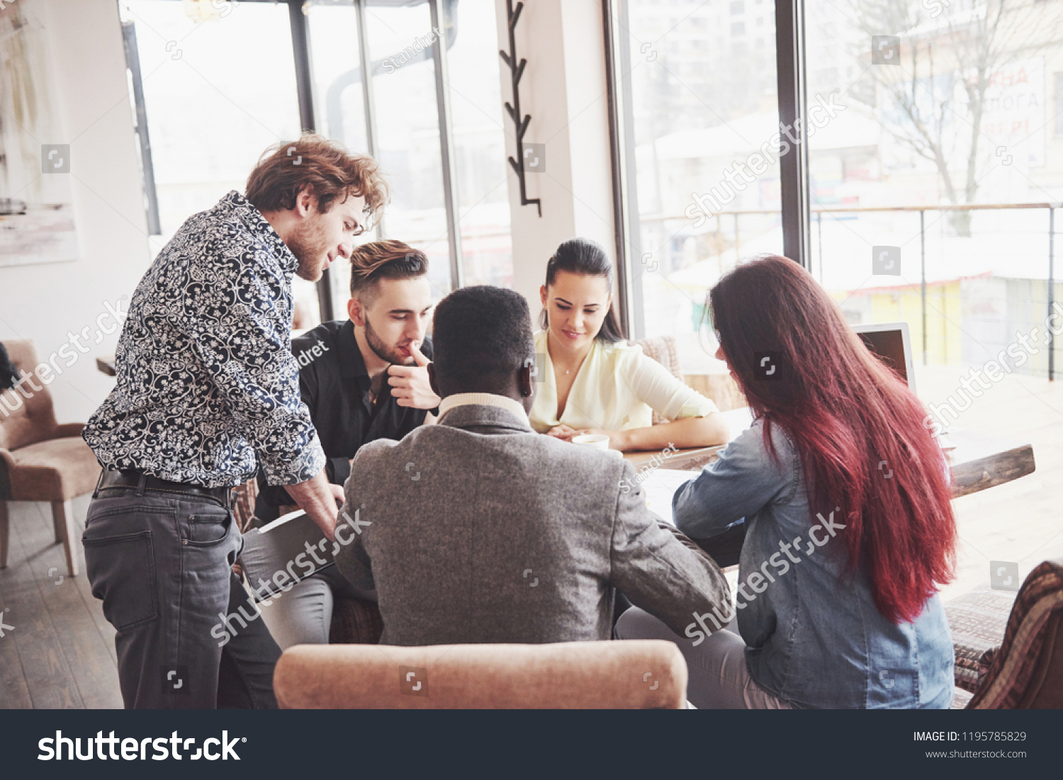 Group of casually dressed businesspeople discussing ideas. Creative professionals gathered for discuss the important issues of the new successful startup project. Teamwork Brainstorming concept. #1195785829