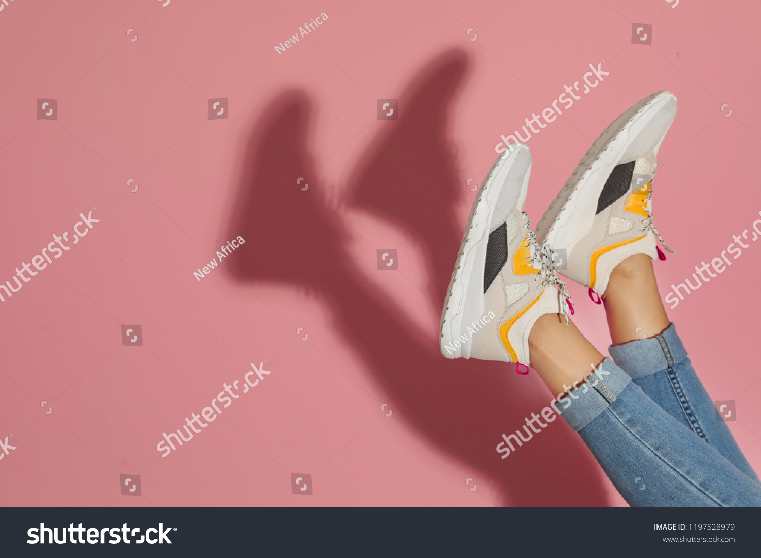 Woman in stylish sneakers near color wall, closeup. Space for text #1197528979