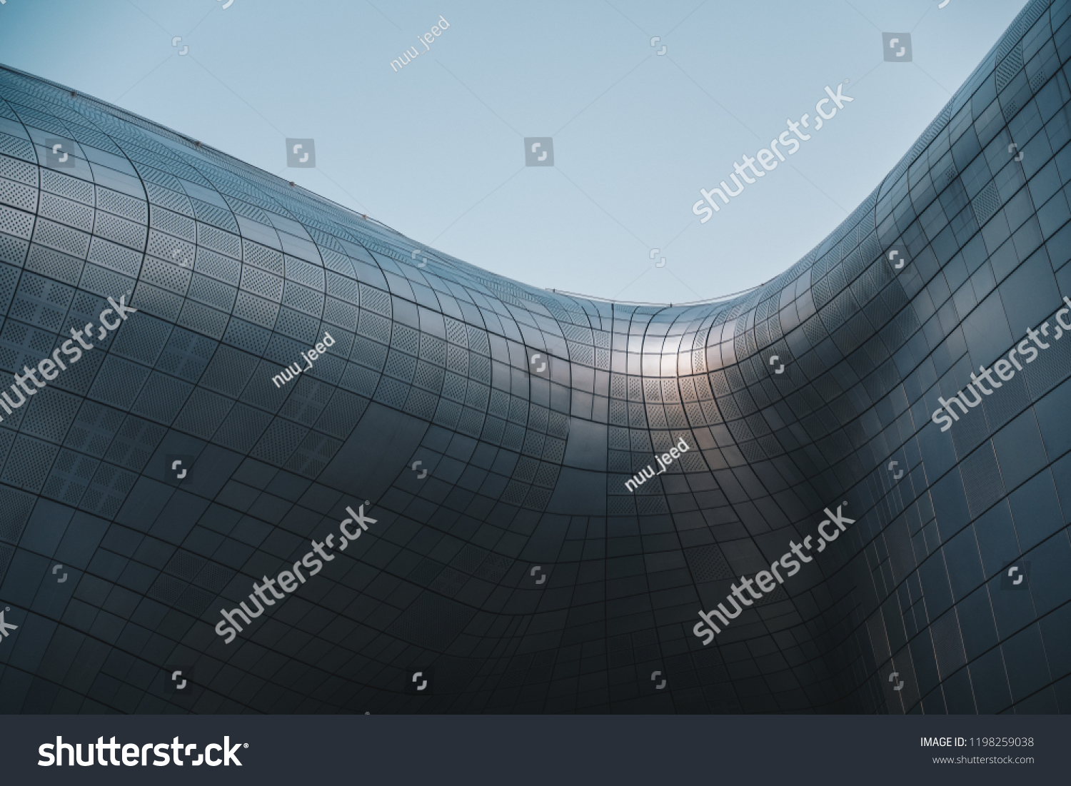 Structural glass facade curving roof and the wooden pathway inside. Modern and Contemporary architectural fiction with glass steel column.Abstract architecture fragment. Dongdaemun Design Plaza (DDP)  #1198259038