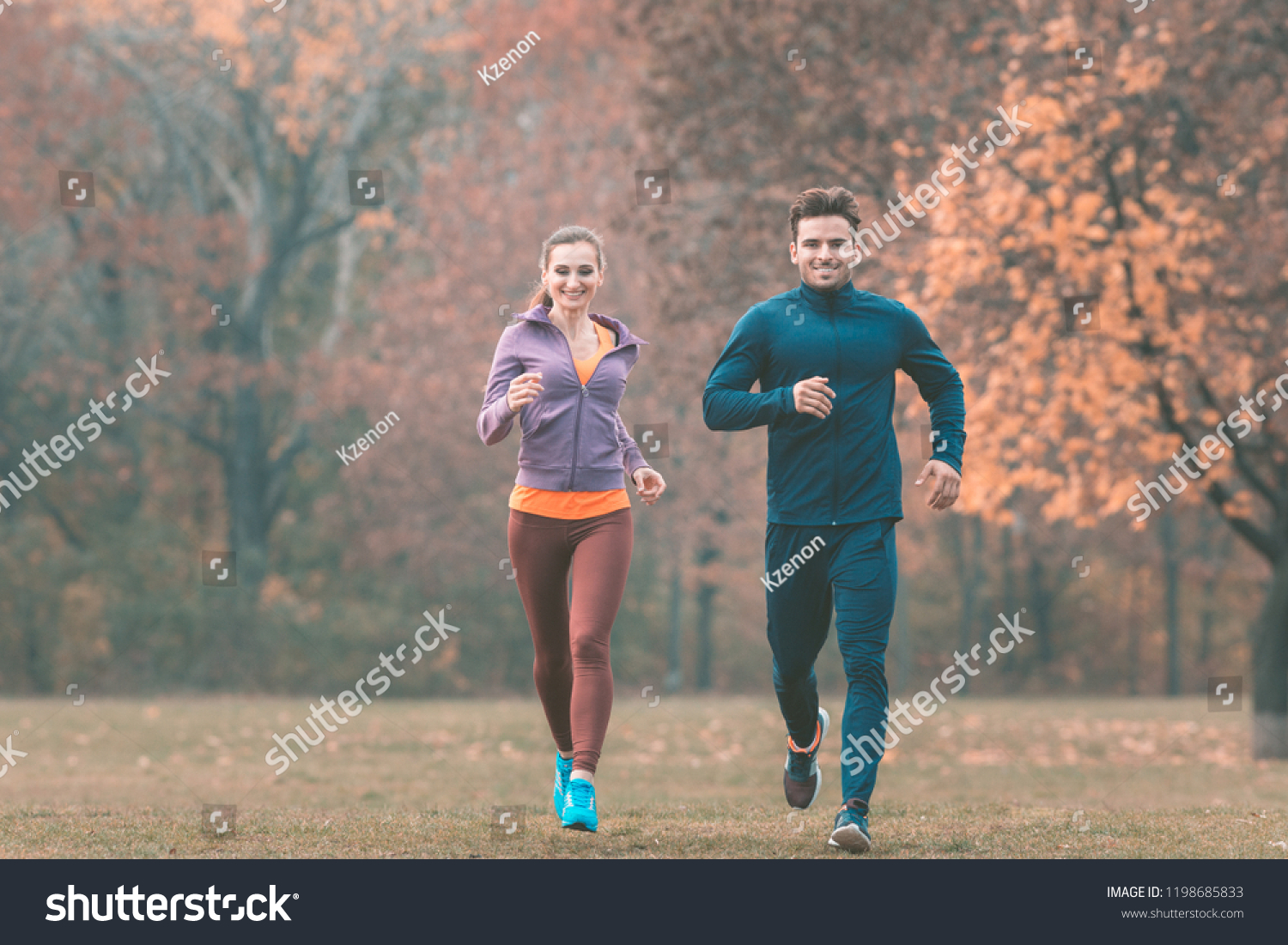 Couple in wonderful fall landscape running for better fitness towards the camera #1198685833