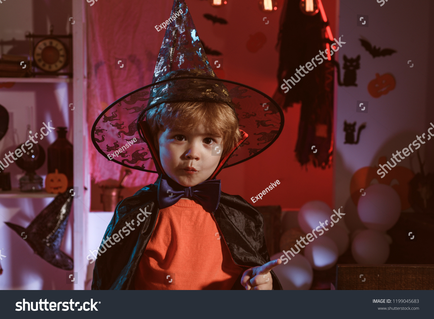 Little cute Halloween wizard. Magic hat. Children play with pumpkins and treat. Secrets of Magic. Holiday concept. Happy halloween #1199045683