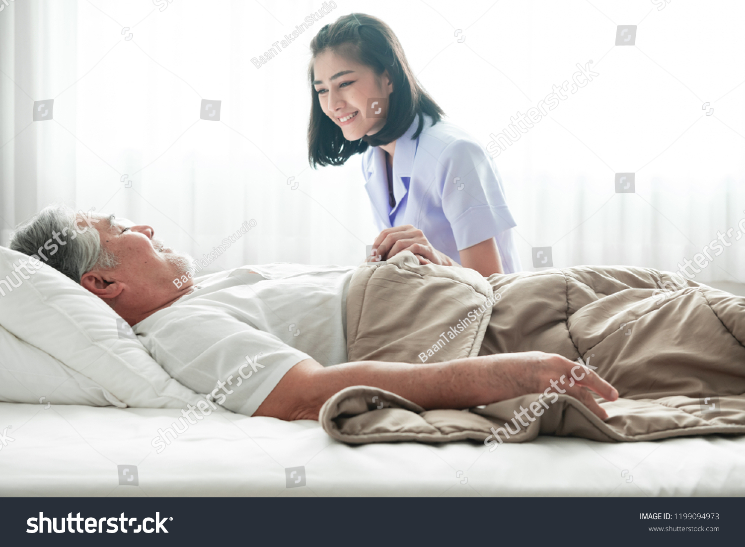 Senior man in bed and nurse woke him up. Old asian man and beautiful asian nurse woman in bedroom and open curtain. Senior home service concept. Close up shot. #1199094973
